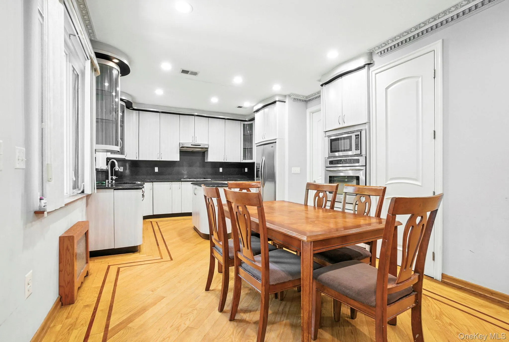 Dining room with light wood-style flooring and recessed lighting Dining room with light wood-style flooring and recessed lighting