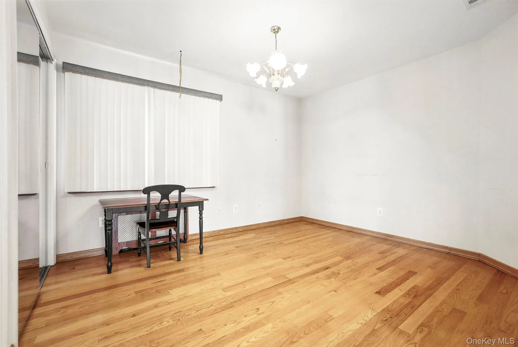 Office featuring light wood-style floors and a chandelier Office featuring light wood-style floors and a chandelier