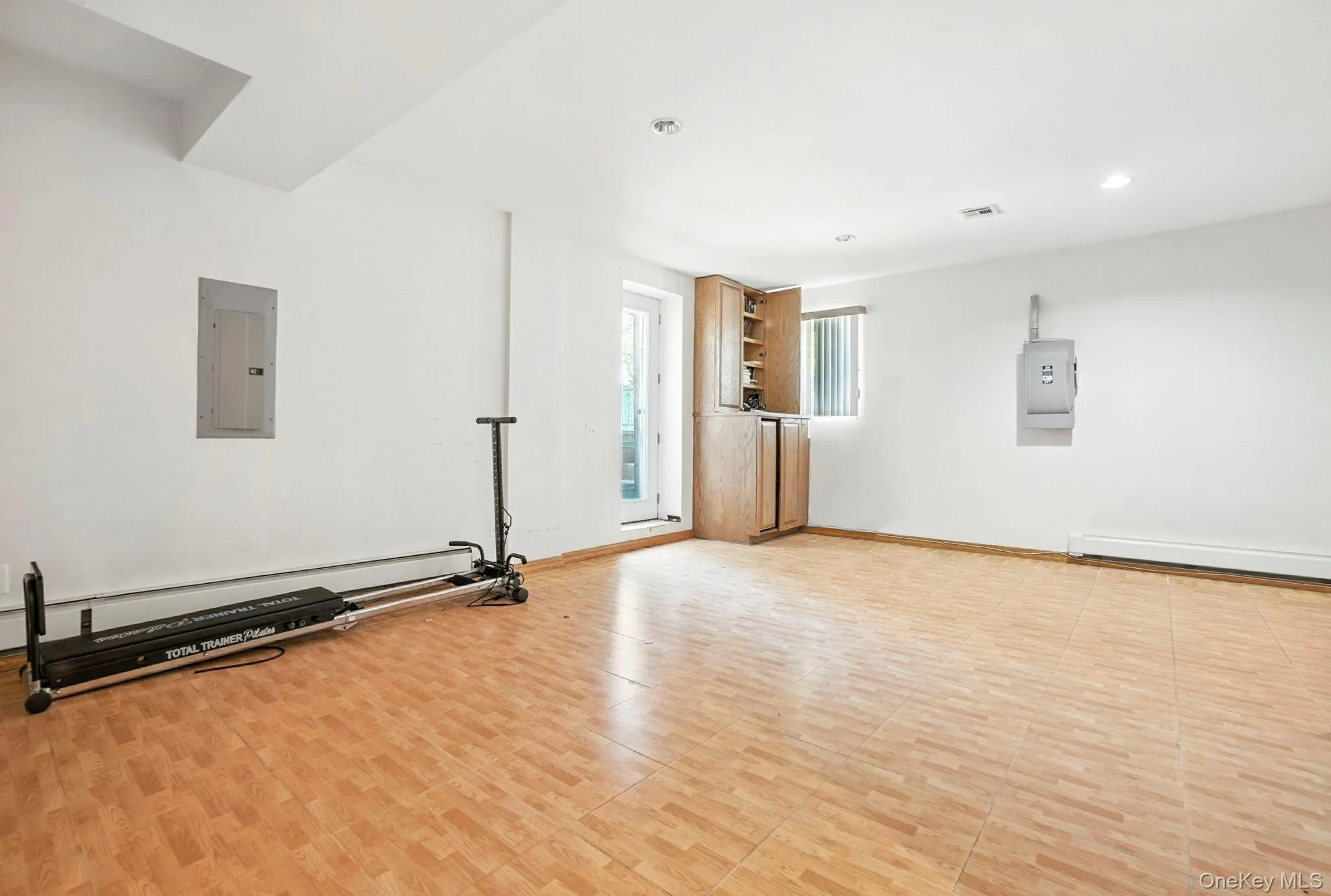 Exercise room with electric panel, a baseboard heating unit, and recessed lighting Exercise room with electric panel, a baseboard heating unit, and recessed lighting