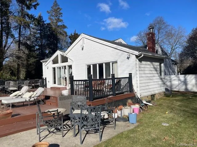 Back of house featuring a patio, a lawn, and a wooden deck Back of house featuring a patio, a lawn, and a wooden deck