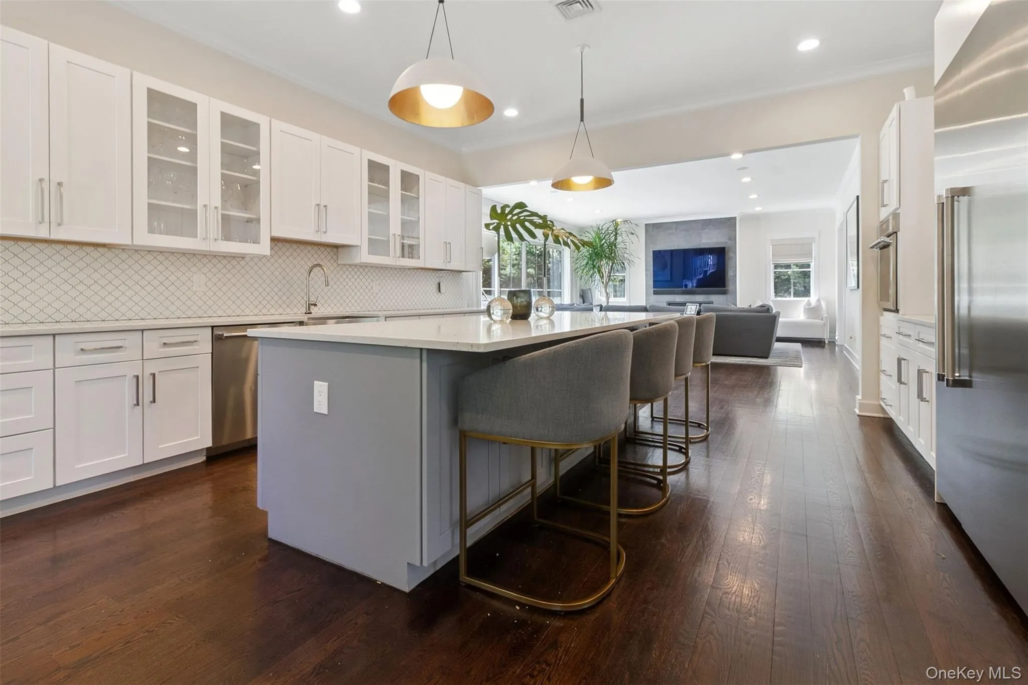 Kitchen featuring white cabinets, backsplash, a kitchen breakfast bar, and recessed lighting Kitchen featuring white cabinets, backsplash, a kitchen breakfast bar, and recessed lighting