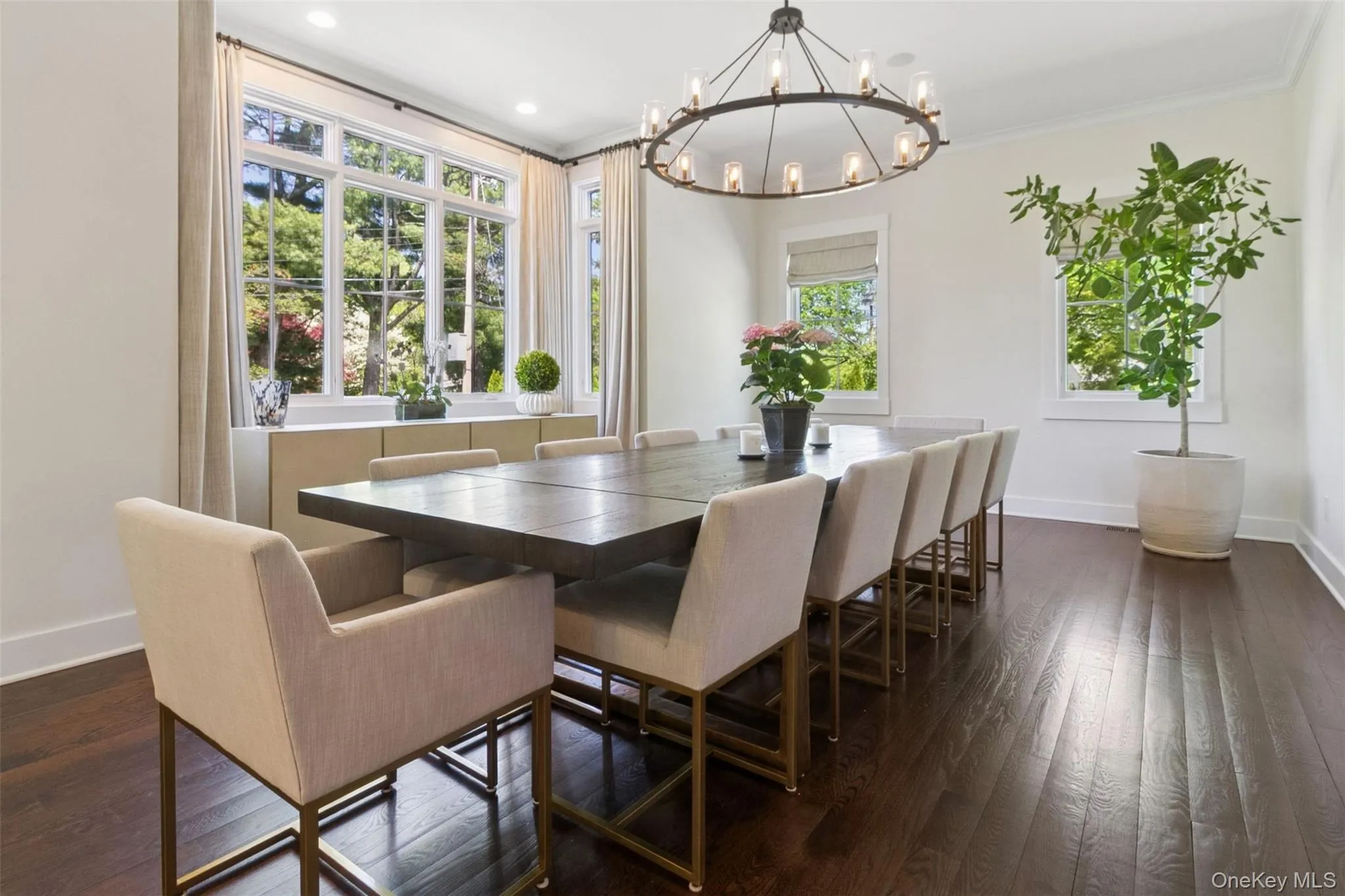 Dining area featuring dark wood-style flooring, ornamental molding, a chandelier, and recessed lighting Dining area featuring dark wood-style flooring, ornamental molding, a chandelier, and recessed lighting