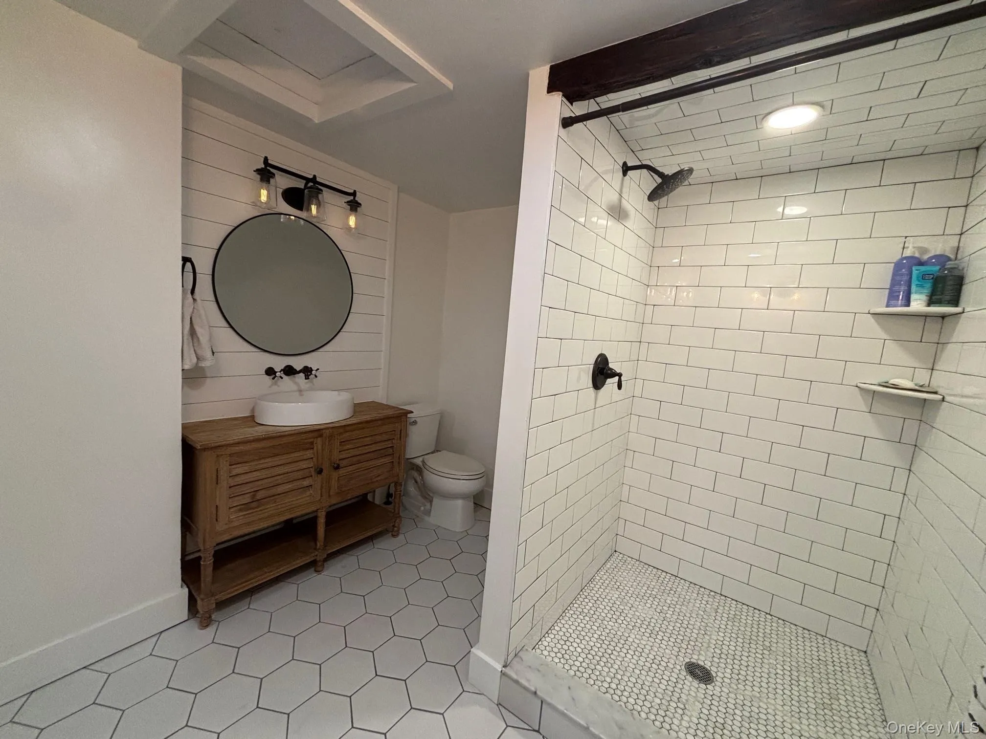 Full bath with vanity, a shower stall, and light tile patterned floors Full bath with vanity, a shower stall, and light tile patterned floors