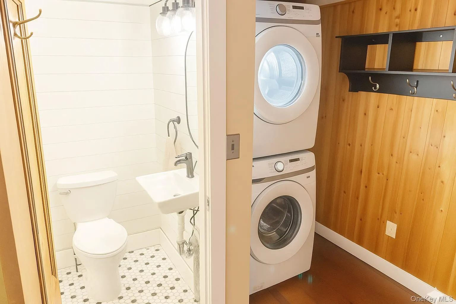 Laundry area featuring wood walls and stacked washer / dryer Laundry area featuring wood walls and stacked washer / dryer