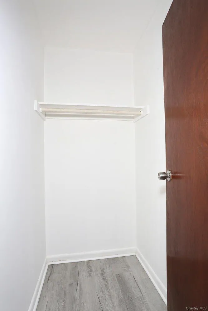 Walk in closet with light wood-style floors Walk in closet with light wood-style floors