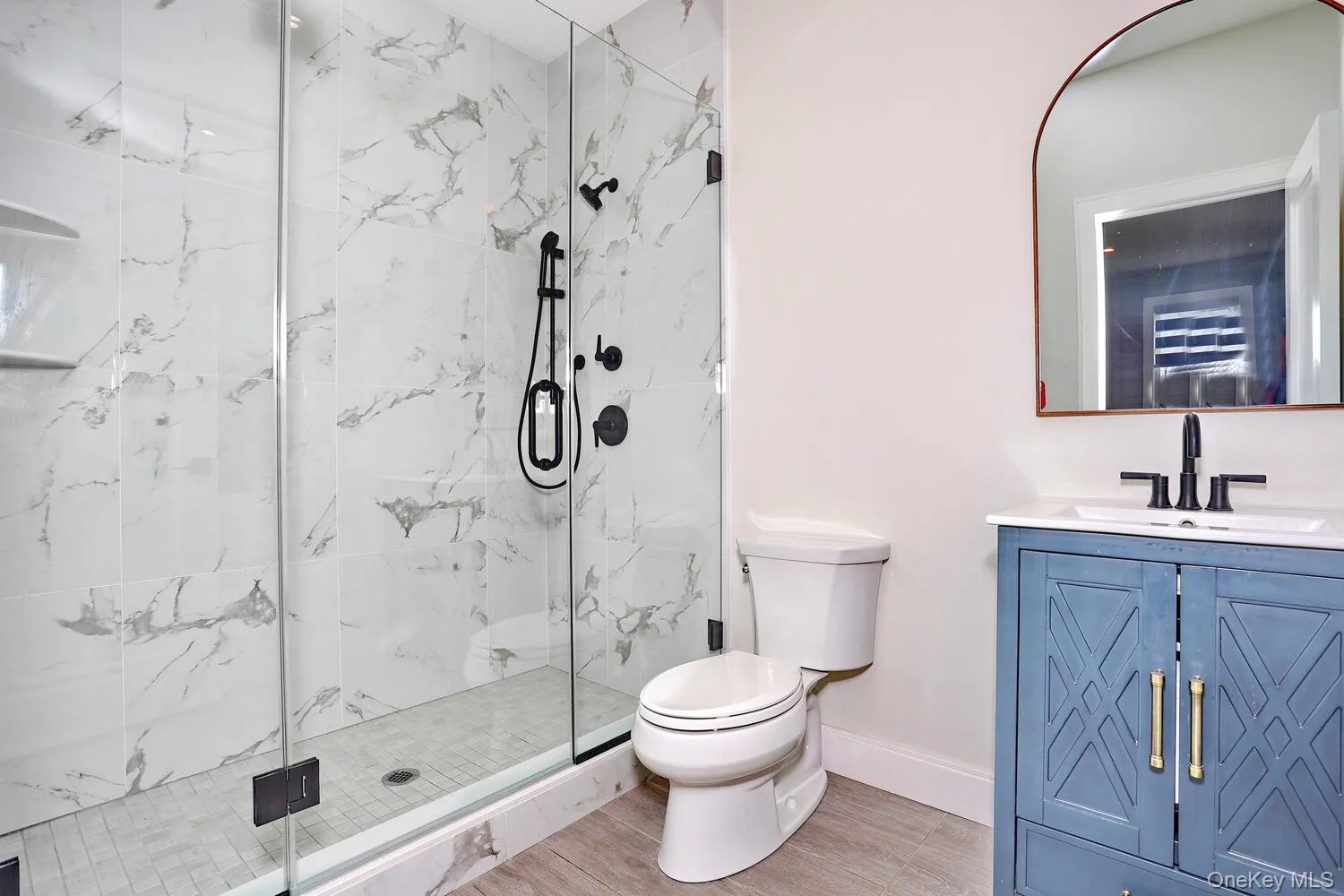 Full bath with vanity and a marble finish shower Full bath with vanity and a marble finish shower