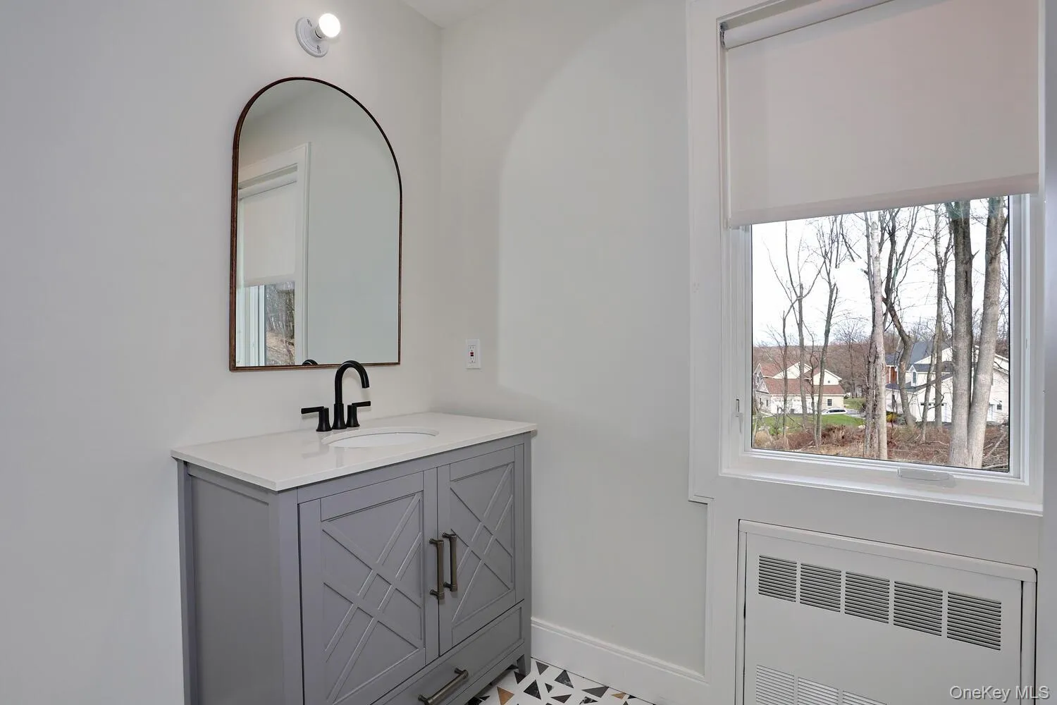 Bathroom featuring radiator, vanity, and a residential view Bathroom featuring radiator, vanity, and a residential view