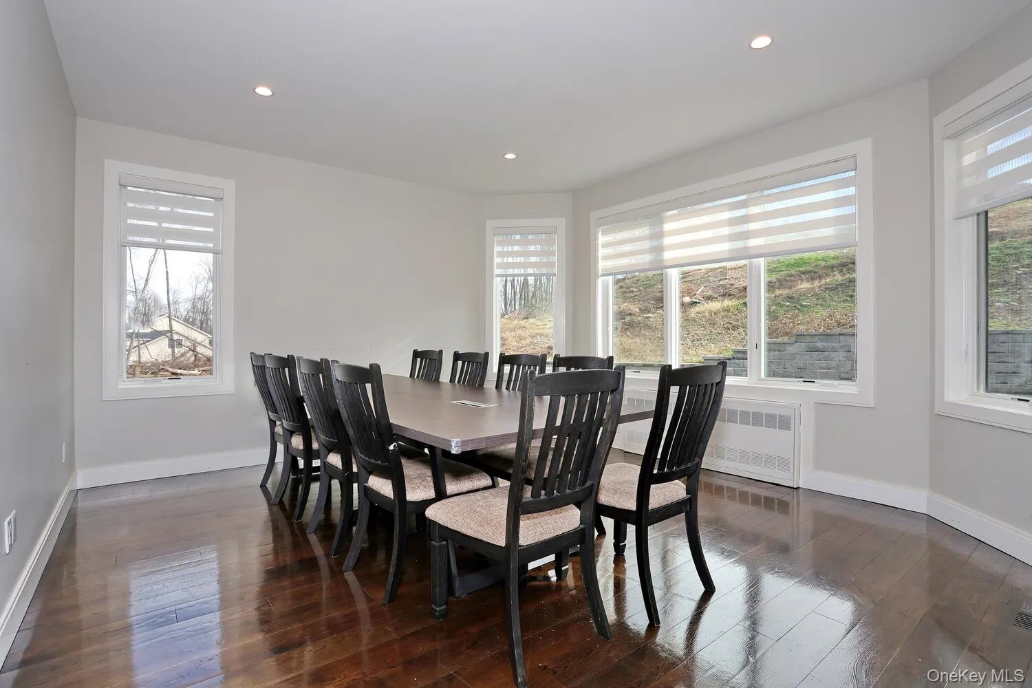 Dining space featuring dark wood-type flooring, recessed lighting, and radiator heating unit Dining space featuring dark wood-type flooring, recessed lighting, and radiator heating unit