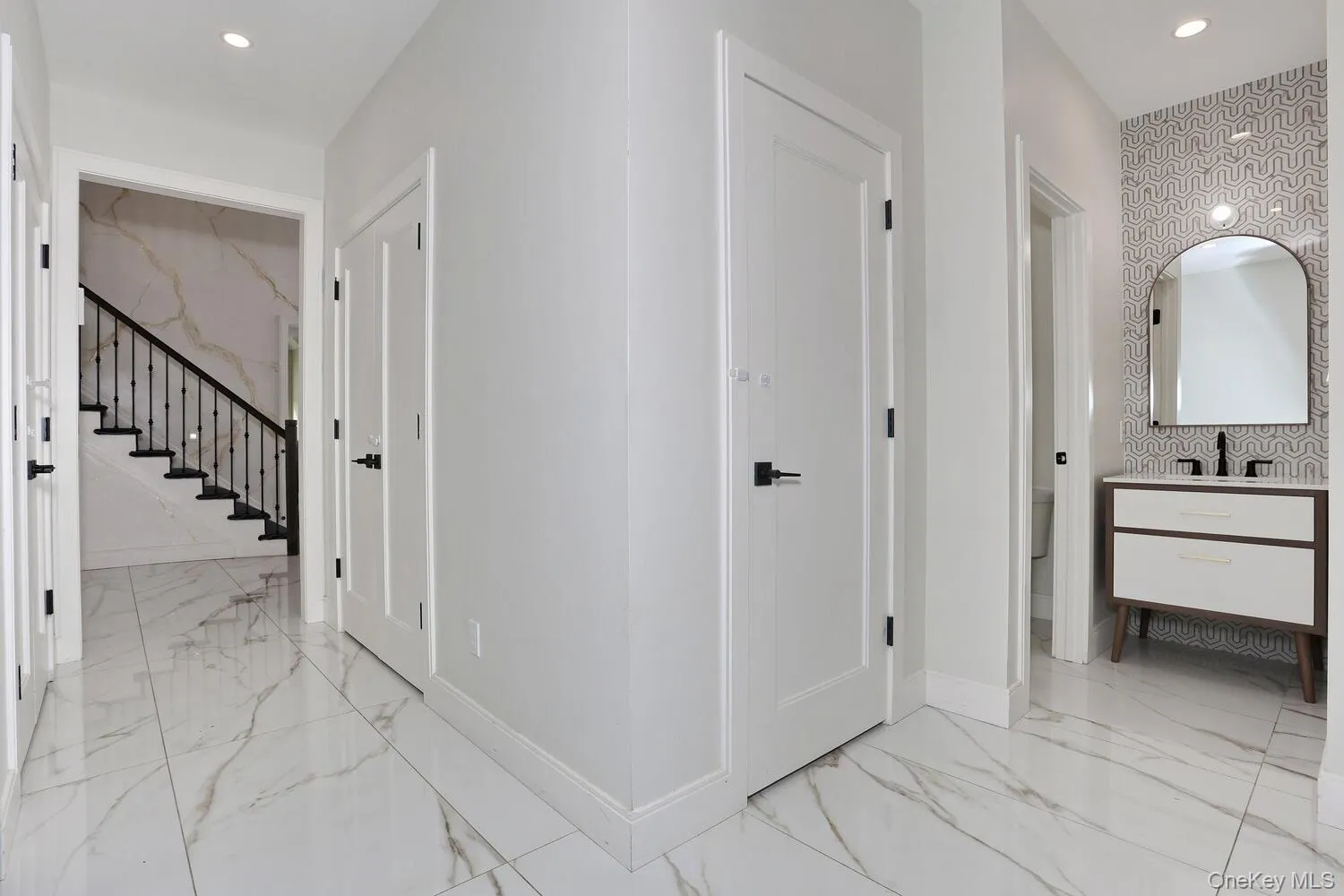 Corridor with recessed lighting, light marble finish flooring, and stairway Corridor with recessed lighting, light marble finish flooring, and stairway