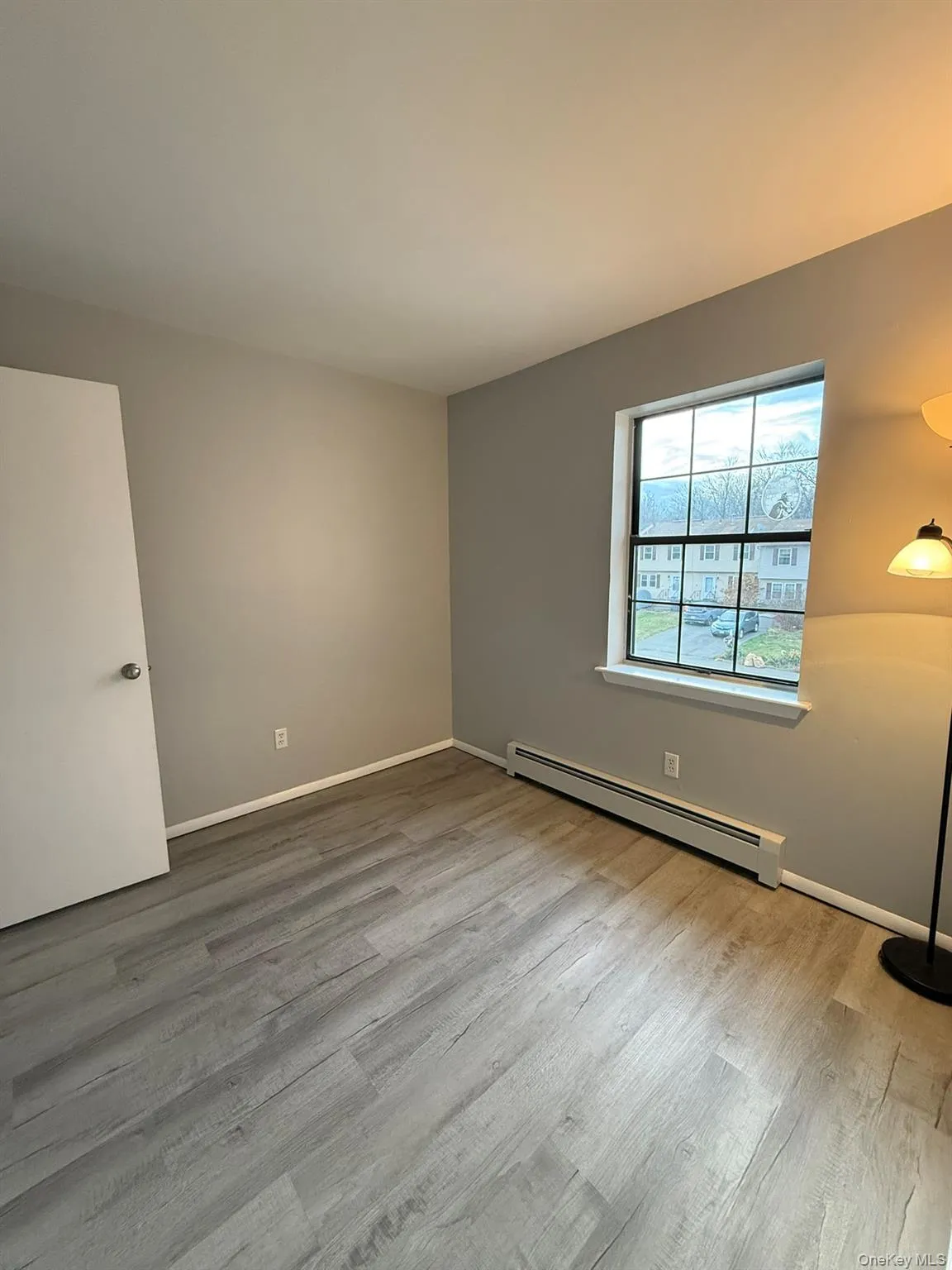 Bedroom #3 with a baseboard heating unit and light wood-type flooring Bedroom #3 with a baseboard heating unit and light wood-type flooring