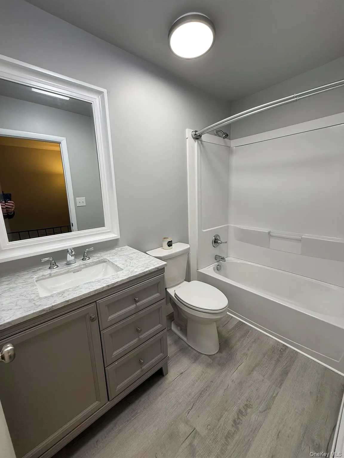 Full bathroom with light wood-style floors, vanity, and shower / bathtub combination Full bathroom with light wood-style floors, vanity, and shower / bathtub combination