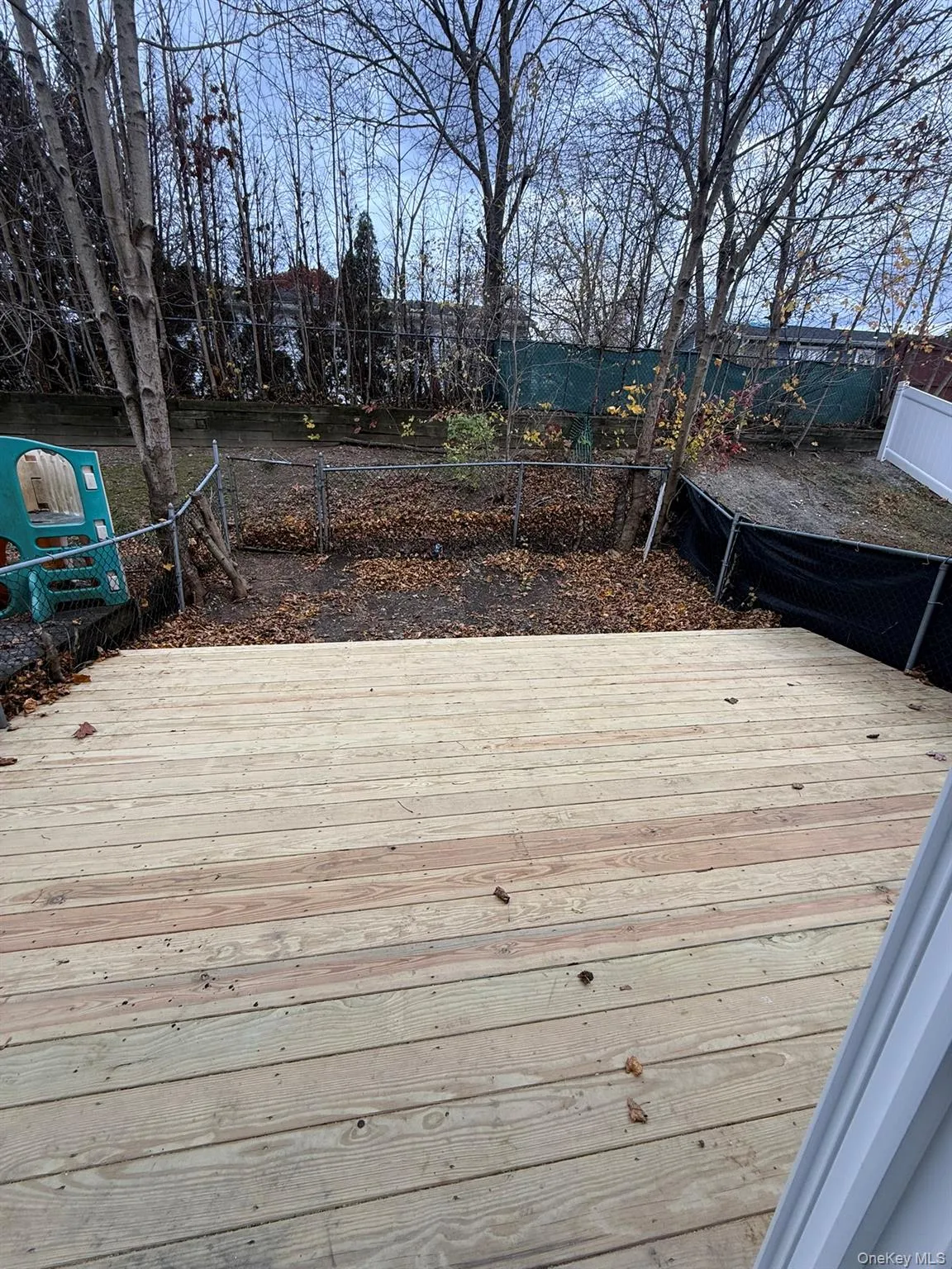 Brand new wooden deck with a fenced backyard Brand new wooden deck with a fenced backyard