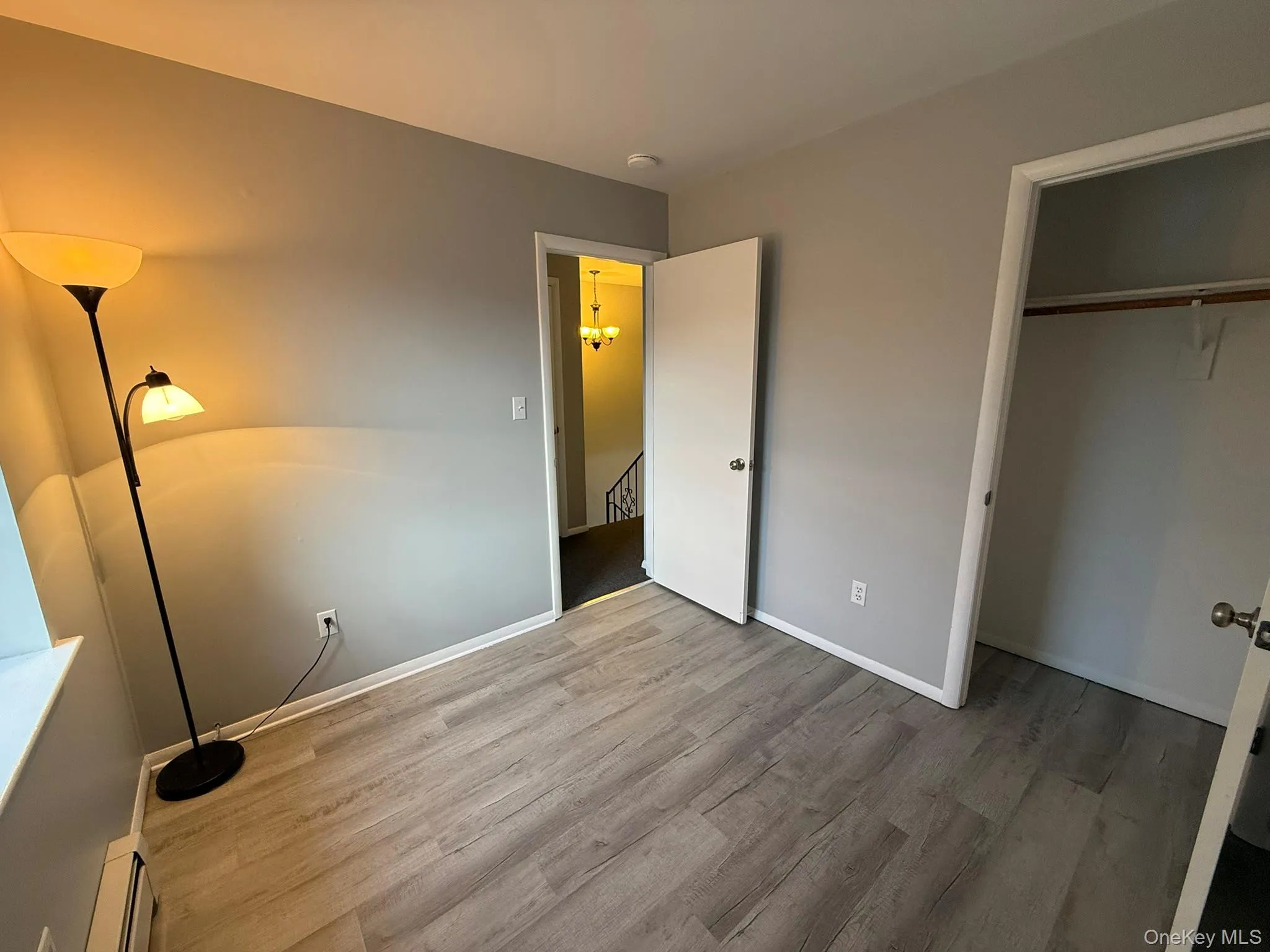 Bedroom #3 with wood finished floors, a baseboard radiator, and a closet Bedroom #3 with wood finished floors, a baseboard radiator, and a closet