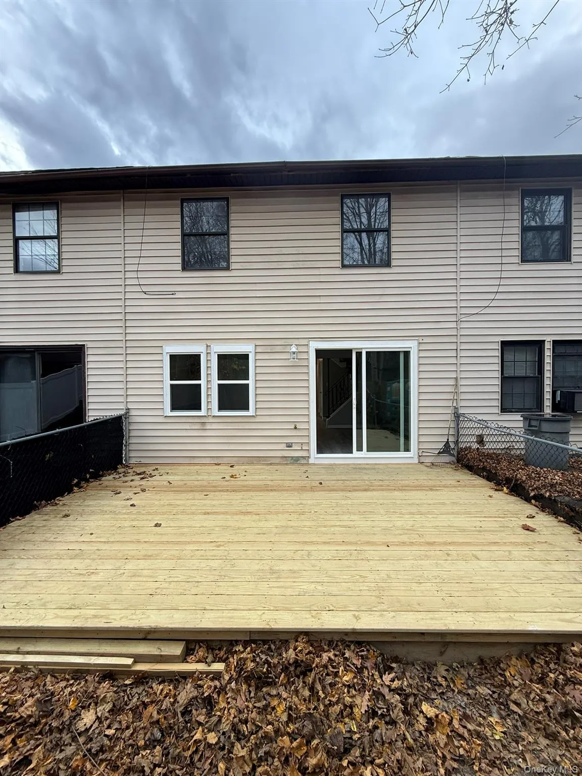 Rear view of house featuring a brand new wooden deck Rear view of house featuring a brand new wooden deck