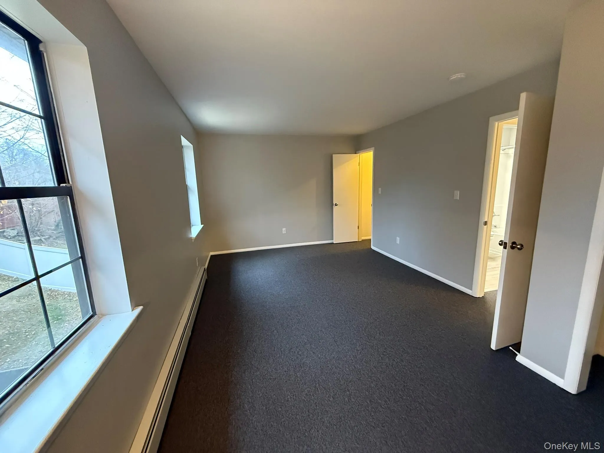 Primary Bedroom with walk in closet, room with a baseboard heating unit, plenty of natural light Primary Bedroom with walk in closet, room with a baseboard heating unit, plenty of natural light