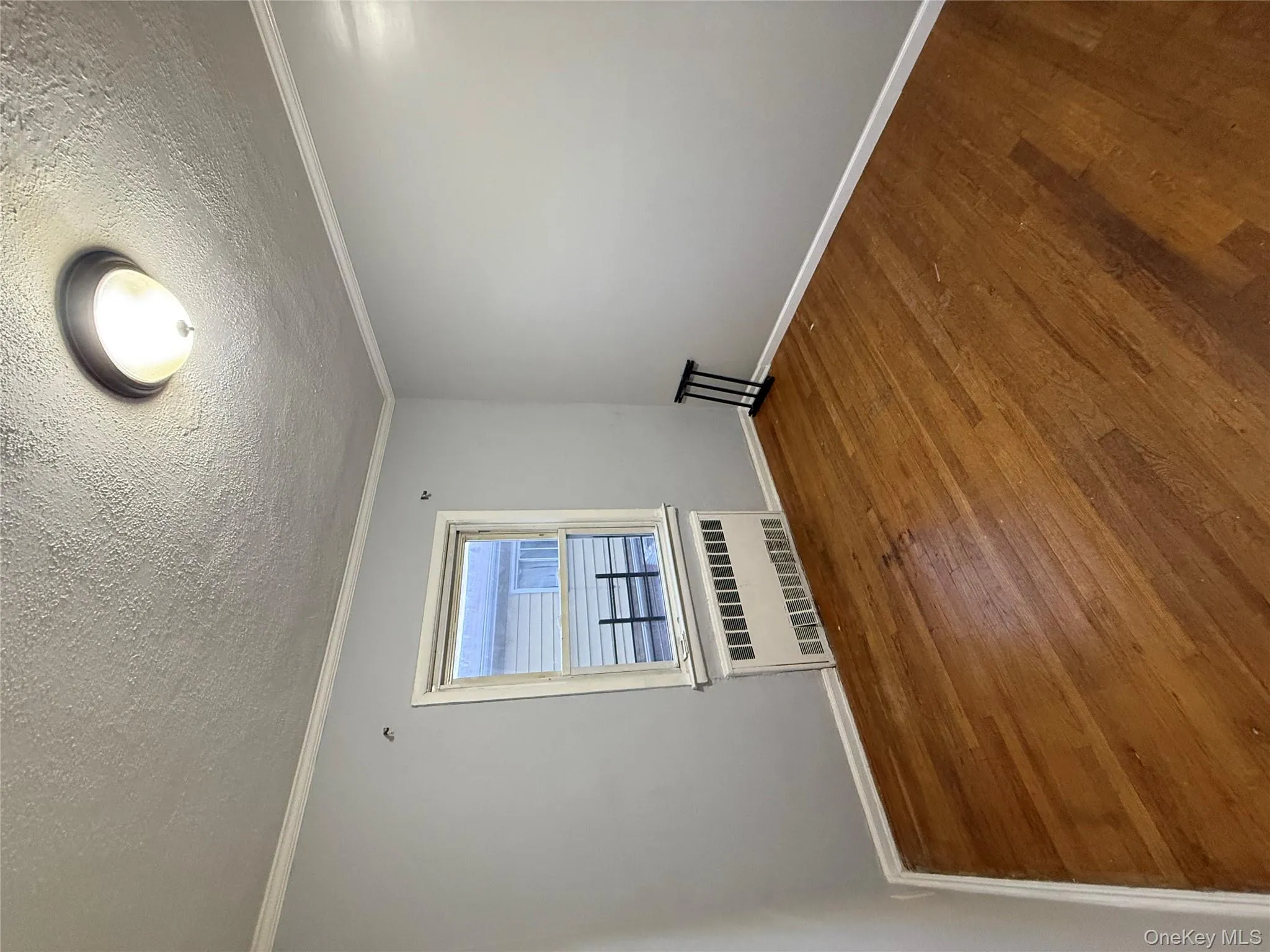 Unfurnished room featuring crown molding, wood finished floors, radiator, and a textured ceiling Unfurnished room featuring crown molding, wood finished floors, radiator, and a textured ceiling