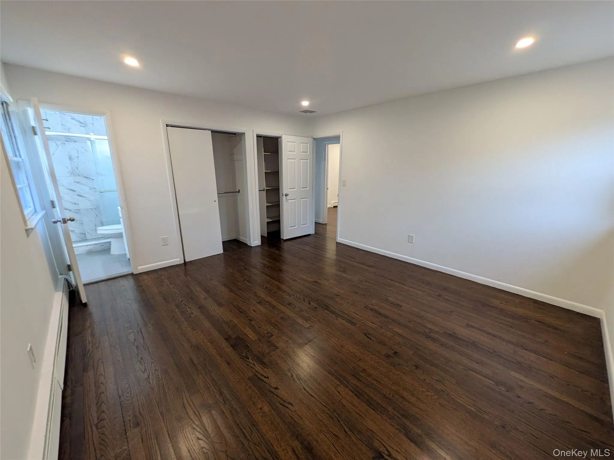 Primary Bedroom with dark stained hardwood floors, two double door closets and a primate full bathroom. Primary Bedroom with dark stained hardwood floors, two double door closets and a primate full bathroom.