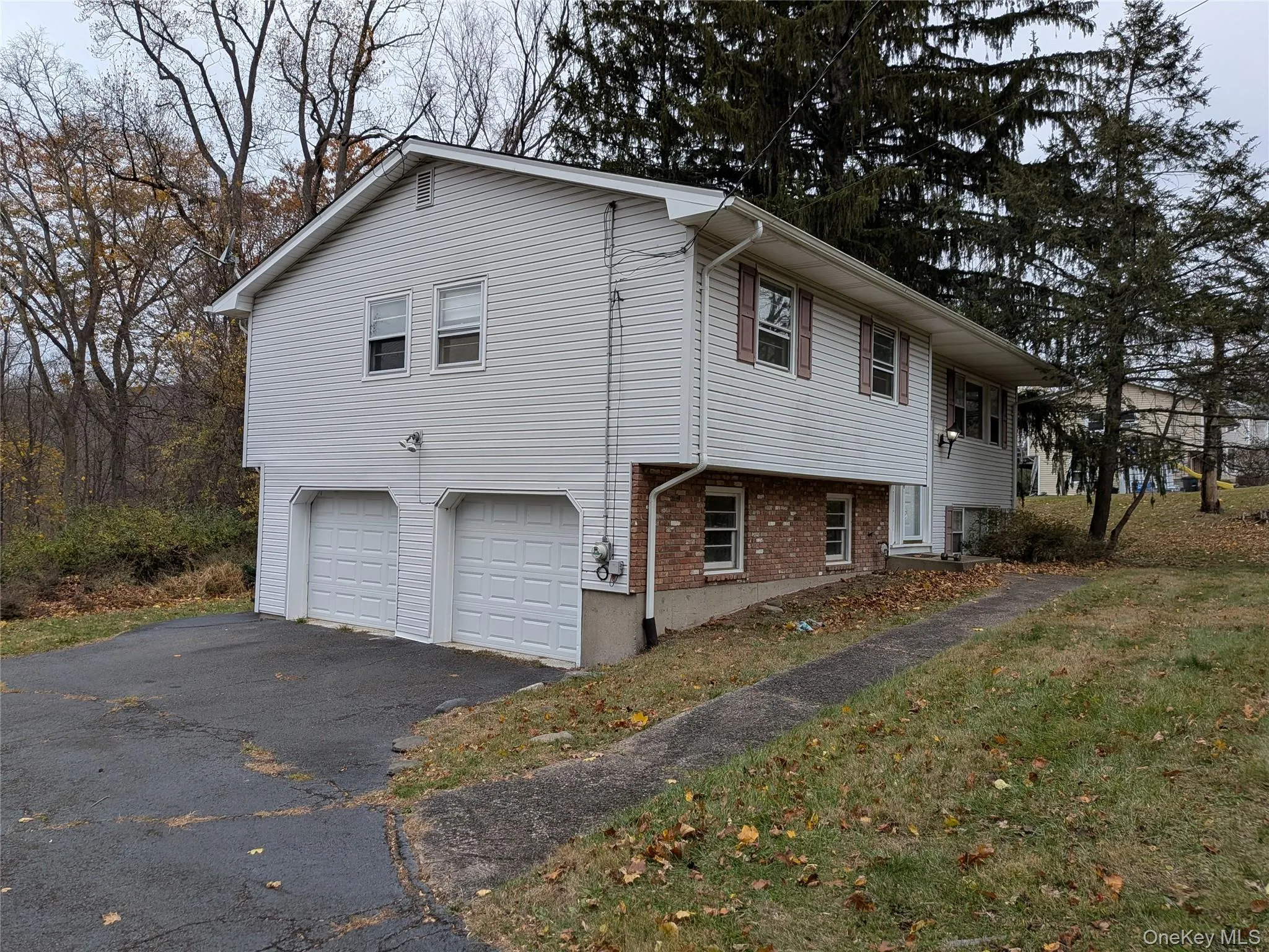 View of property exterior featuring brick siding, an attached garage, and asphalt driveway View of property exterior featuring brick siding, an attached garage, and asphalt driveway