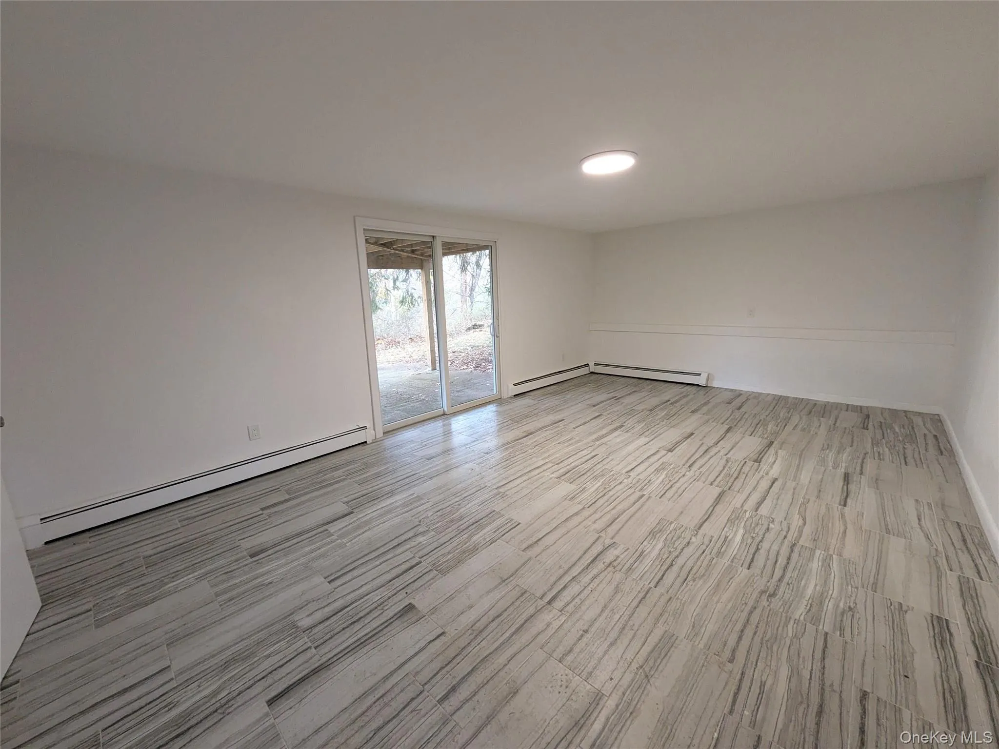 Unfurnished room with a baseboard heating unit and light wood-style flooring Unfurnished room with a baseboard heating unit and light wood-style flooring