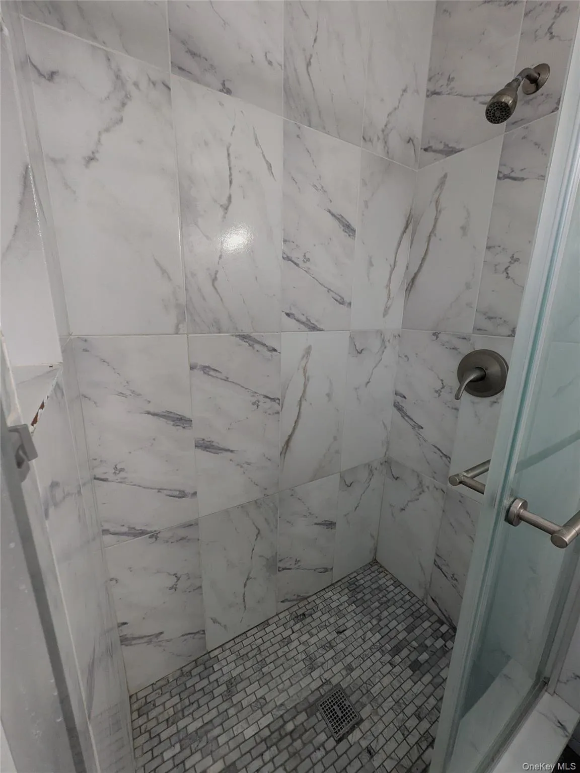 Primary full bathroom with tiled shower with glass doors. Primary full bathroom with tiled shower with glass doors.