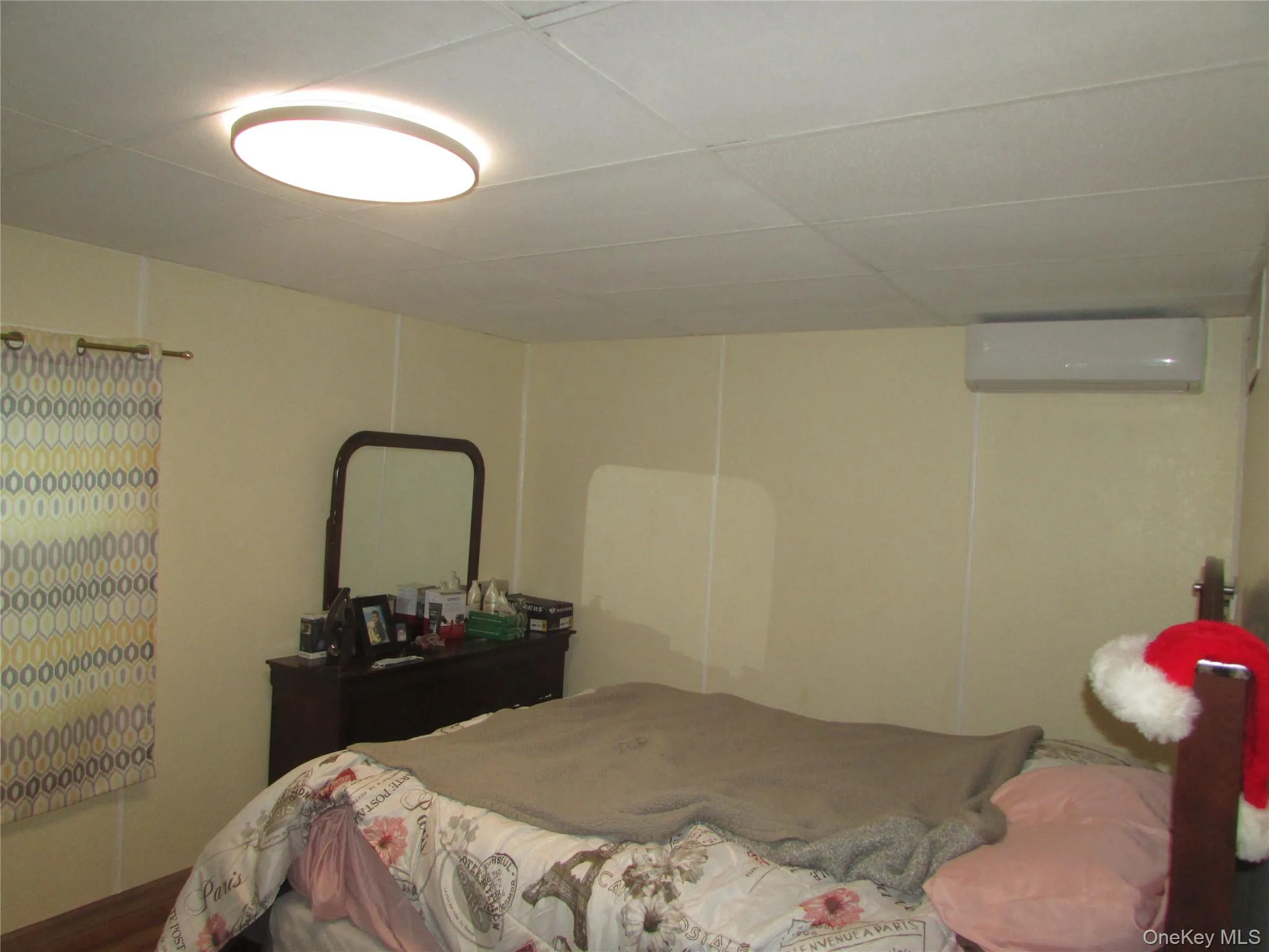 Bedroom with a drop ceiling and a wall mounted air conditioner Bedroom with a drop ceiling and a wall mounted air conditioner