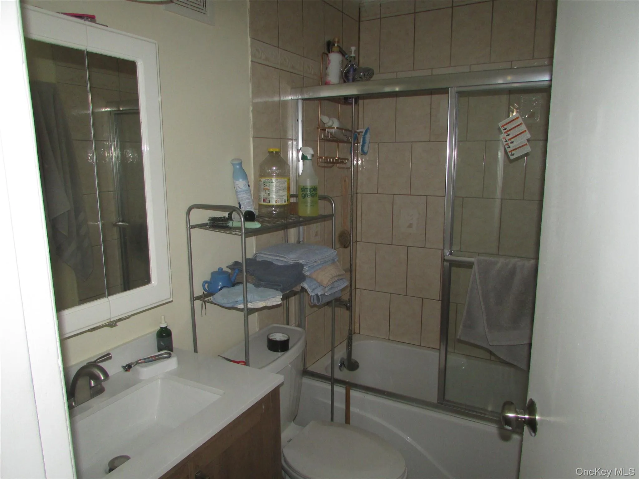 Bathroom with combined bath / shower with glass door and vanity Bathroom with combined bath / shower with glass door and vanity
