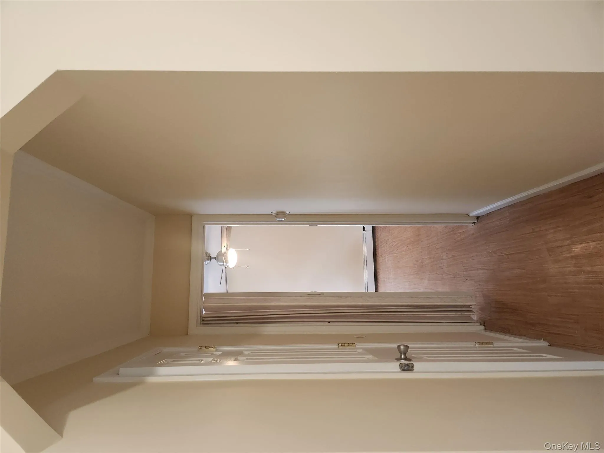 Hall with wood finished floors and a baseboard heating unit Hall with wood finished floors and a baseboard heating unit