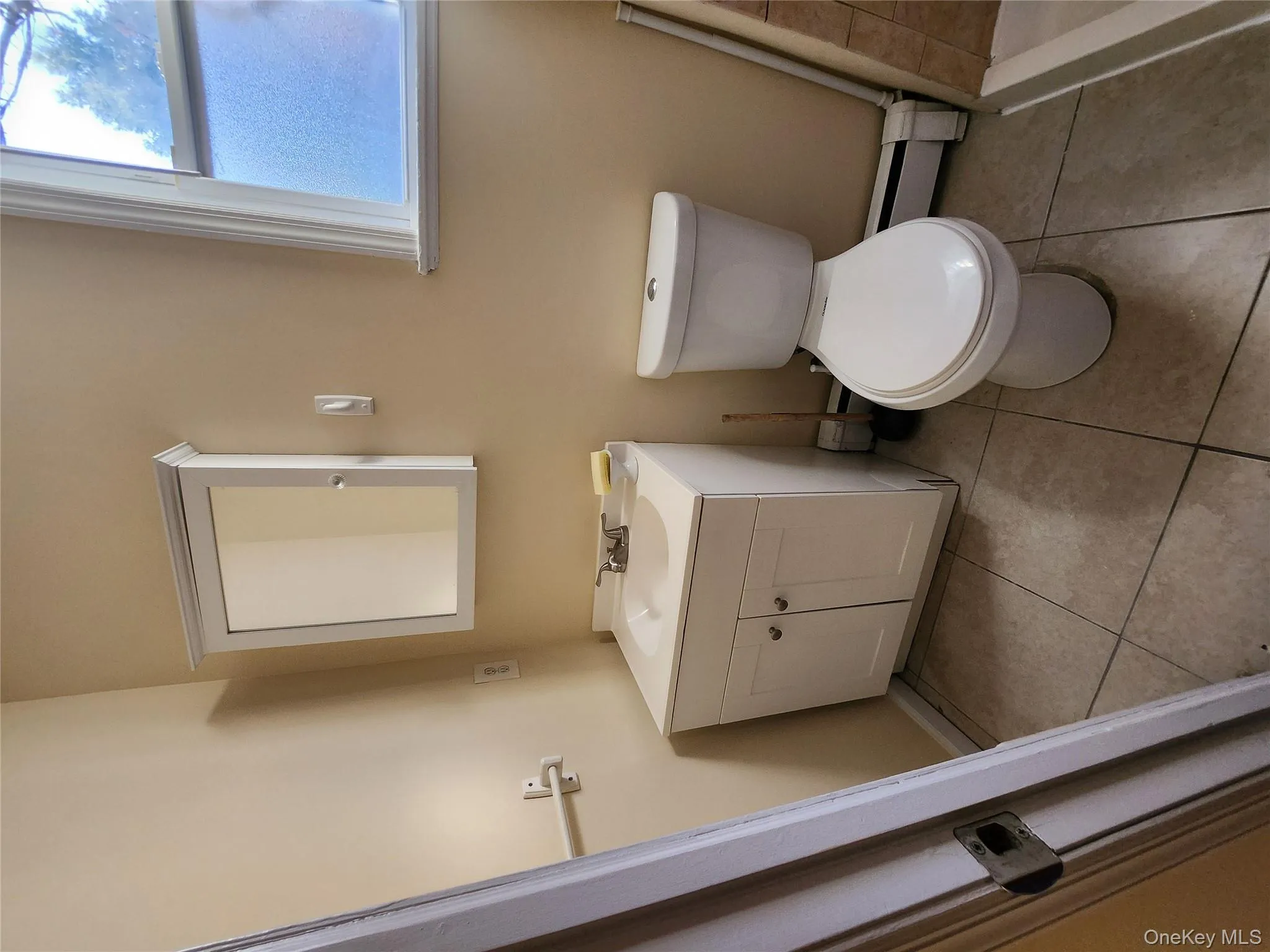 Full bath with vanity, a baseboard radiator, and light tile patterned floors Full bath with vanity, a baseboard radiator, and light tile patterned floors