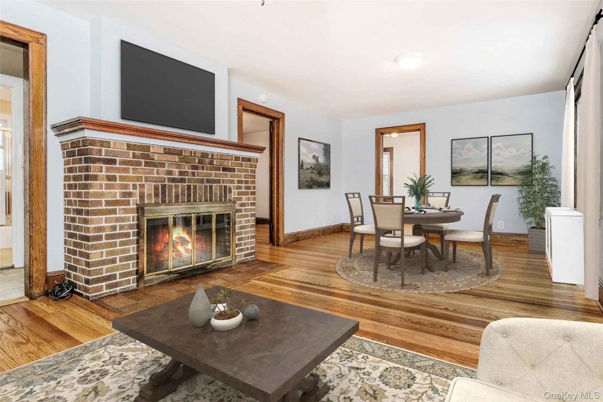 A view of the living room w/ a wood burning brick fireplace & dining area. Virtually staged A view of the living room w/ a wood burning brick fireplace & dining area. Virtually staged