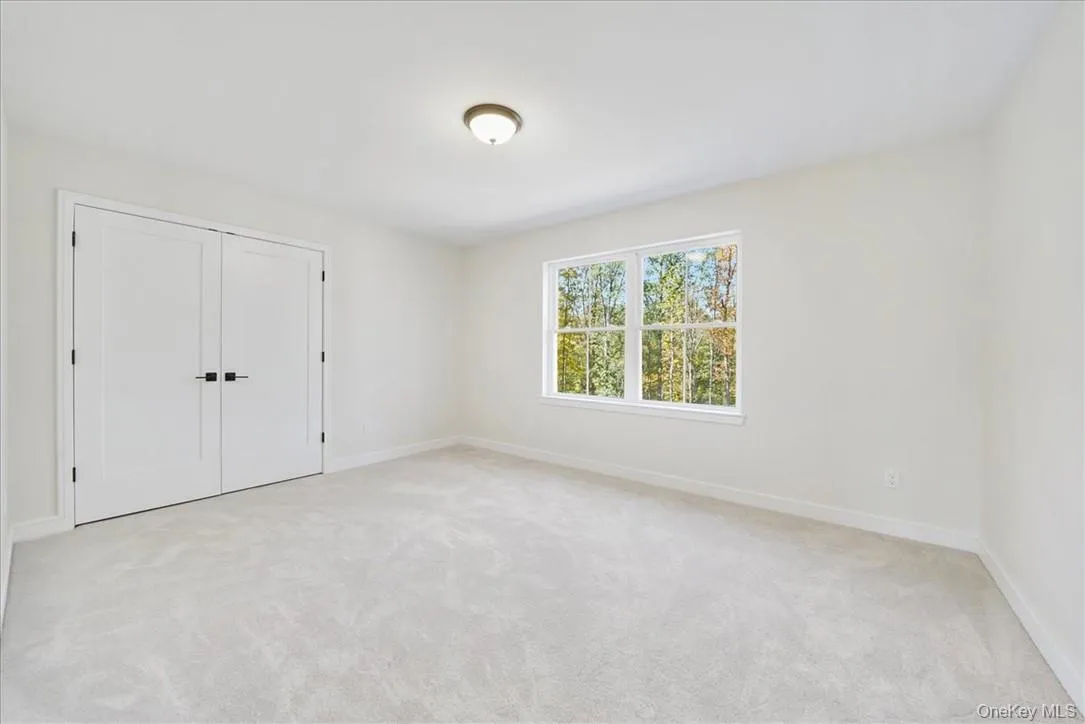 Unfurnished bedroom with light carpet and a closet Unfurnished bedroom with light carpet and a closet