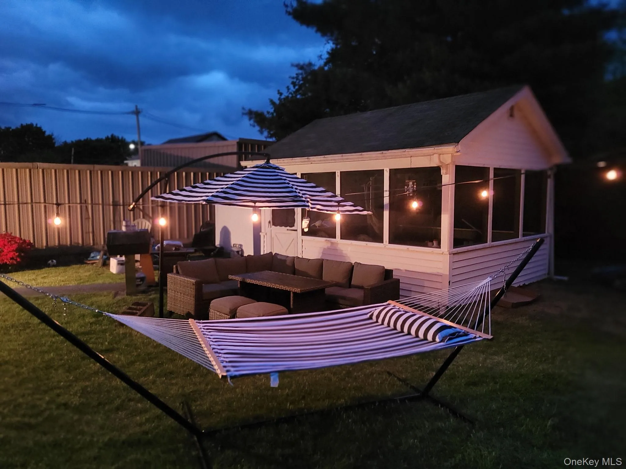 Patio at night with a sunroom, a patio, and an outdoor hangout area Patio at night with a sunroom, a patio, and an outdoor hangout area