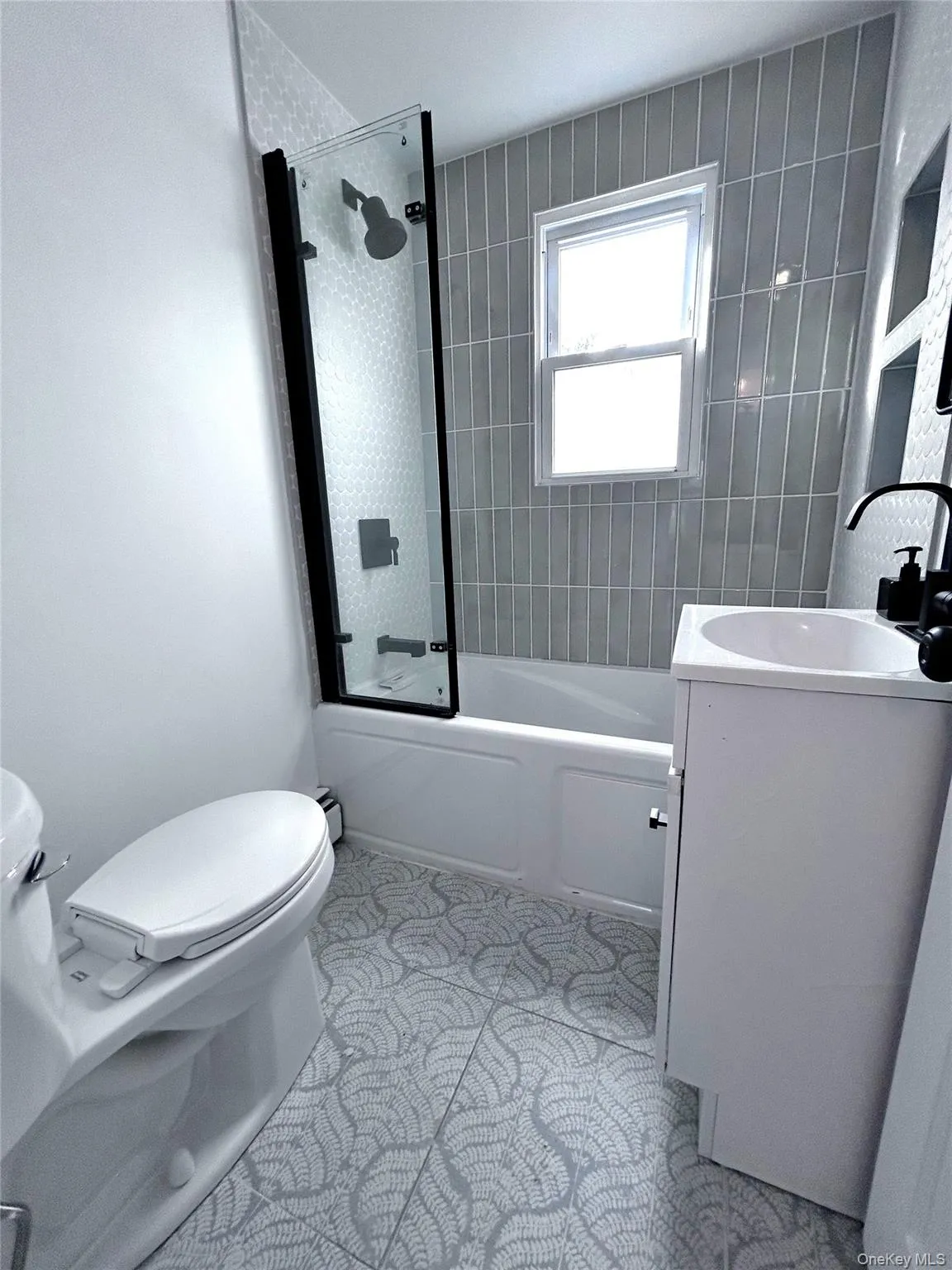 Bathroom with shower combination, vanity, and light tile patterned flooring Bathroom with shower combination, vanity, and light tile patterned flooring