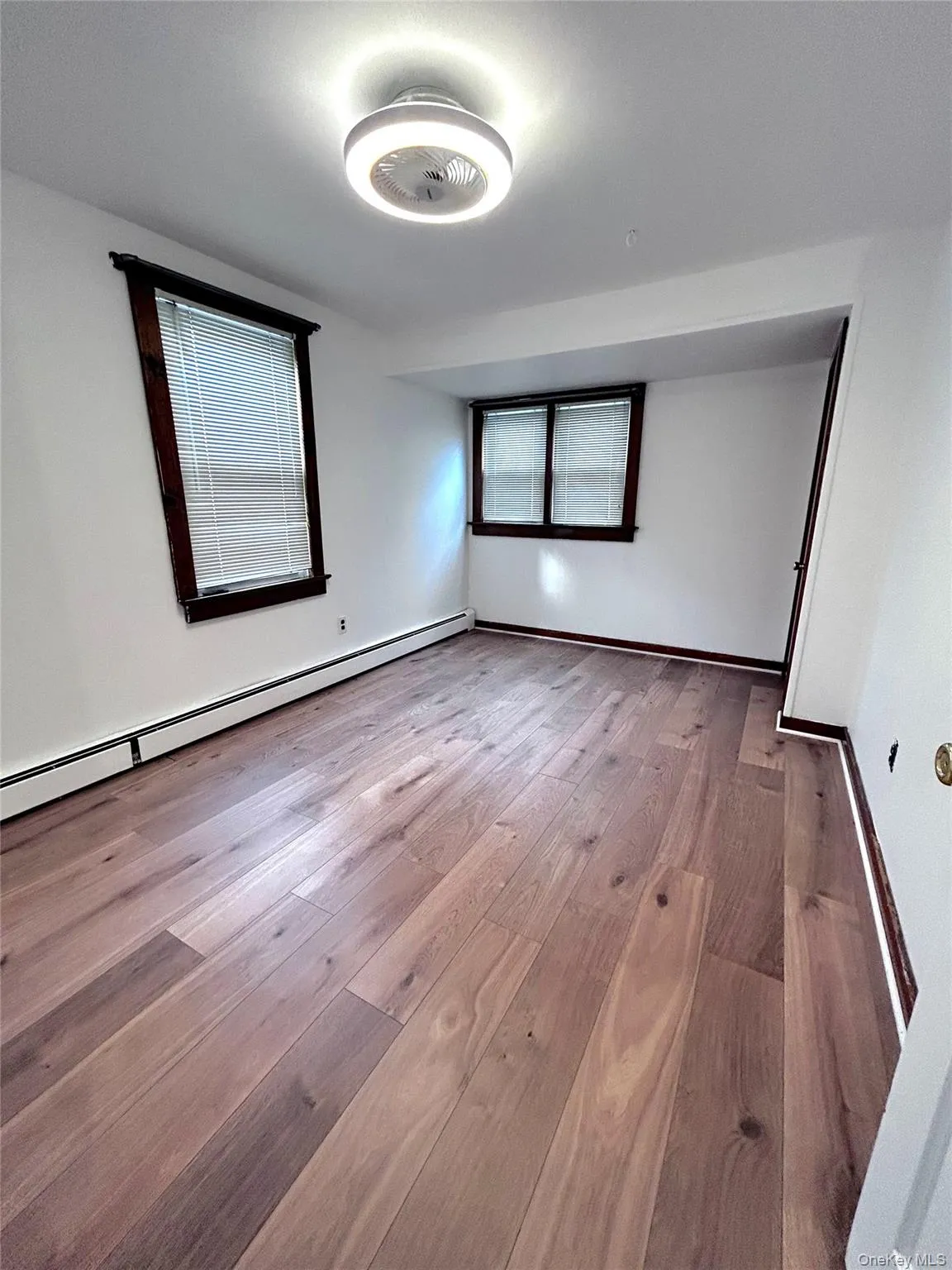 Spare room featuring a baseboard radiator and light wood-style floors Spare room featuring a baseboard radiator and light wood-style floors