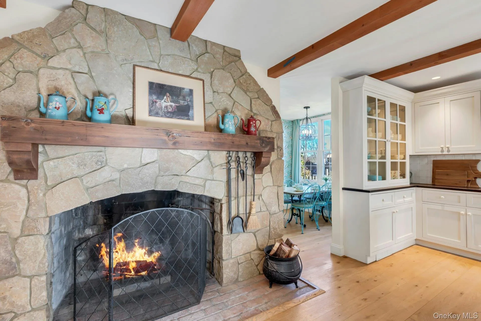 Detailed view of beamed ceiling, wood finished floors, a fireplace, and tasteful backsplash Detailed view of beamed ceiling, wood finished floors, a fireplace, and tasteful backsplash