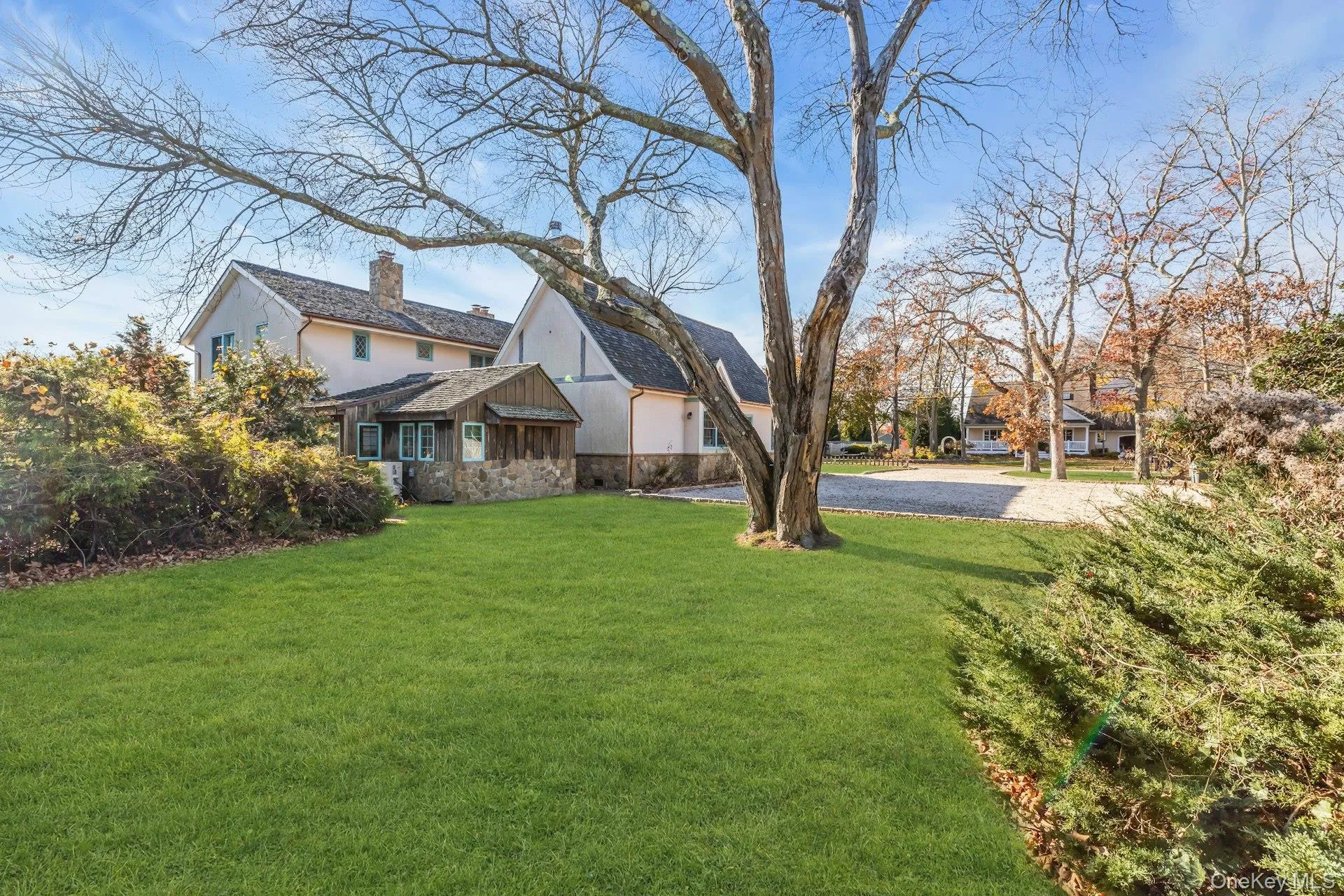 View of front of property with a front lawn, a chimney, and stone siding View of front of property with a front lawn, a chimney, and stone siding