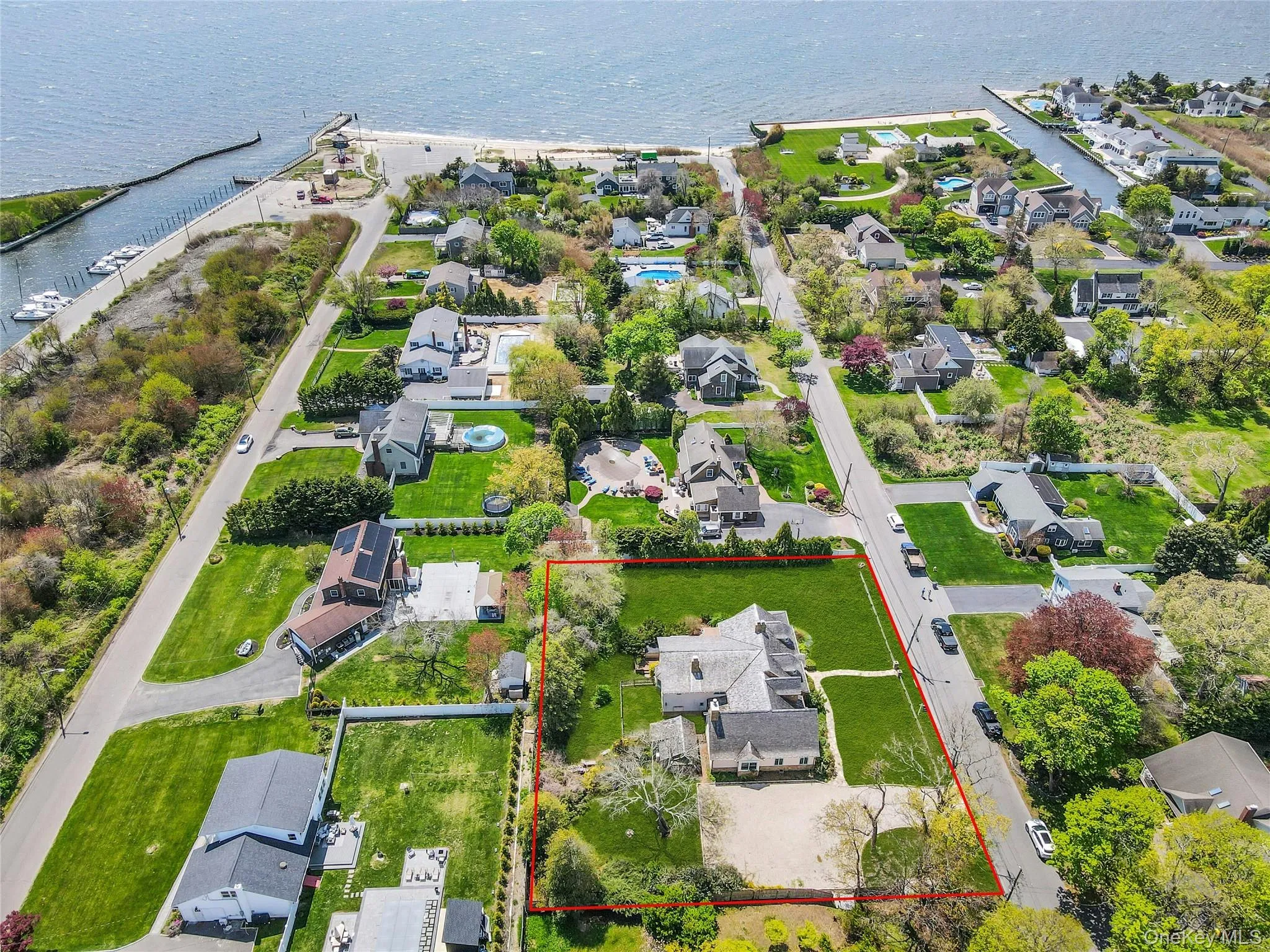 Expansive property just 5 houses from the Great South Bay featuring a sizable residential structure, extensive green lawn, and gravel driveway Expansive property just 5 houses from the Great South Bay featuring a sizable residential structure, extensive green lawn, and gravel driveway