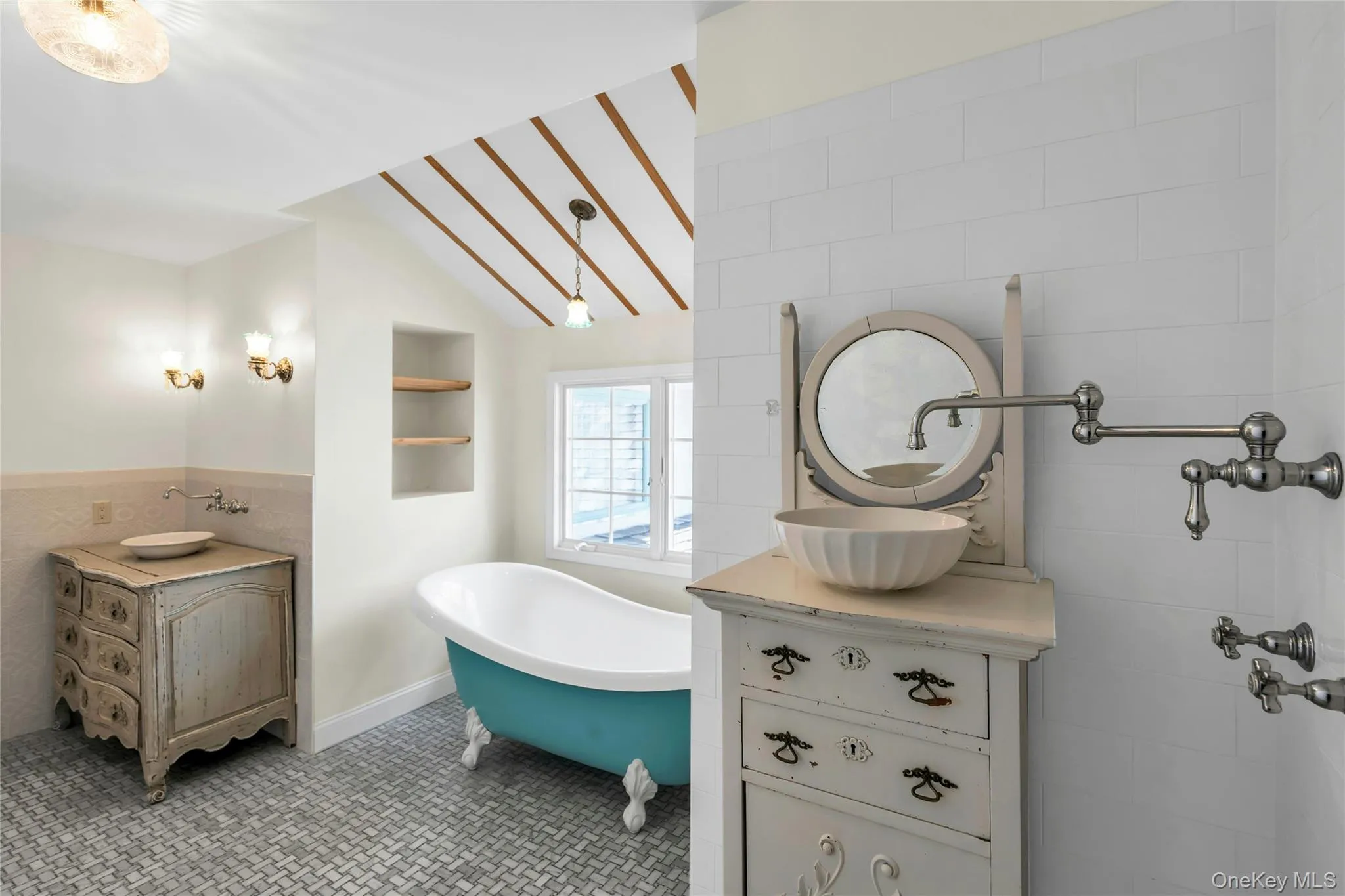 Bathroom featuring a clawfoot tub, recessed shelving, and a window for natural light Bathroom featuring a clawfoot tub, recessed shelving, and a window for natural light