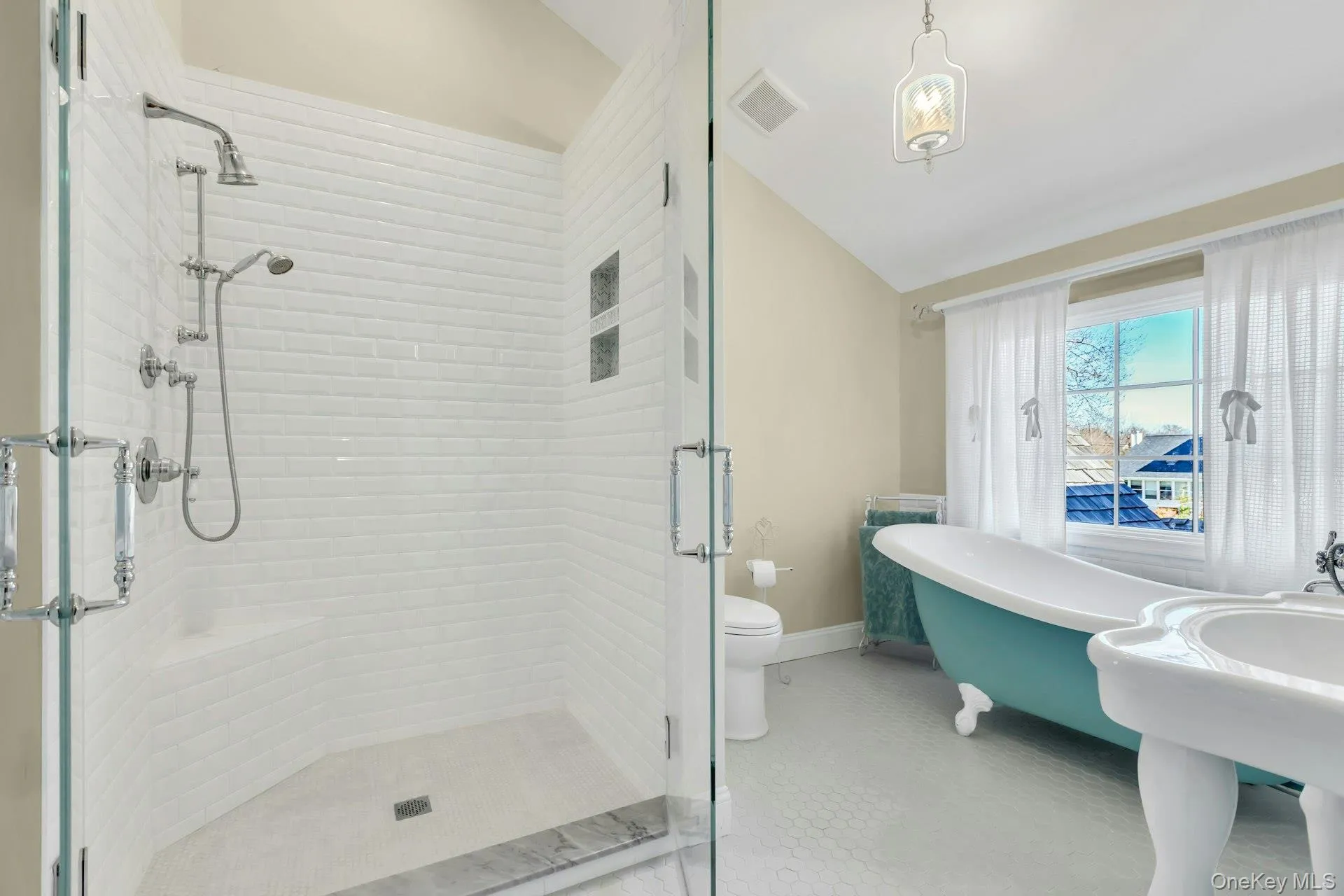 Bathroom with vaulted ceiling, a freestanding bath, a stall shower, and light tile patterned flooring Bathroom with vaulted ceiling, a freestanding bath, a stall shower, and light tile patterned flooring