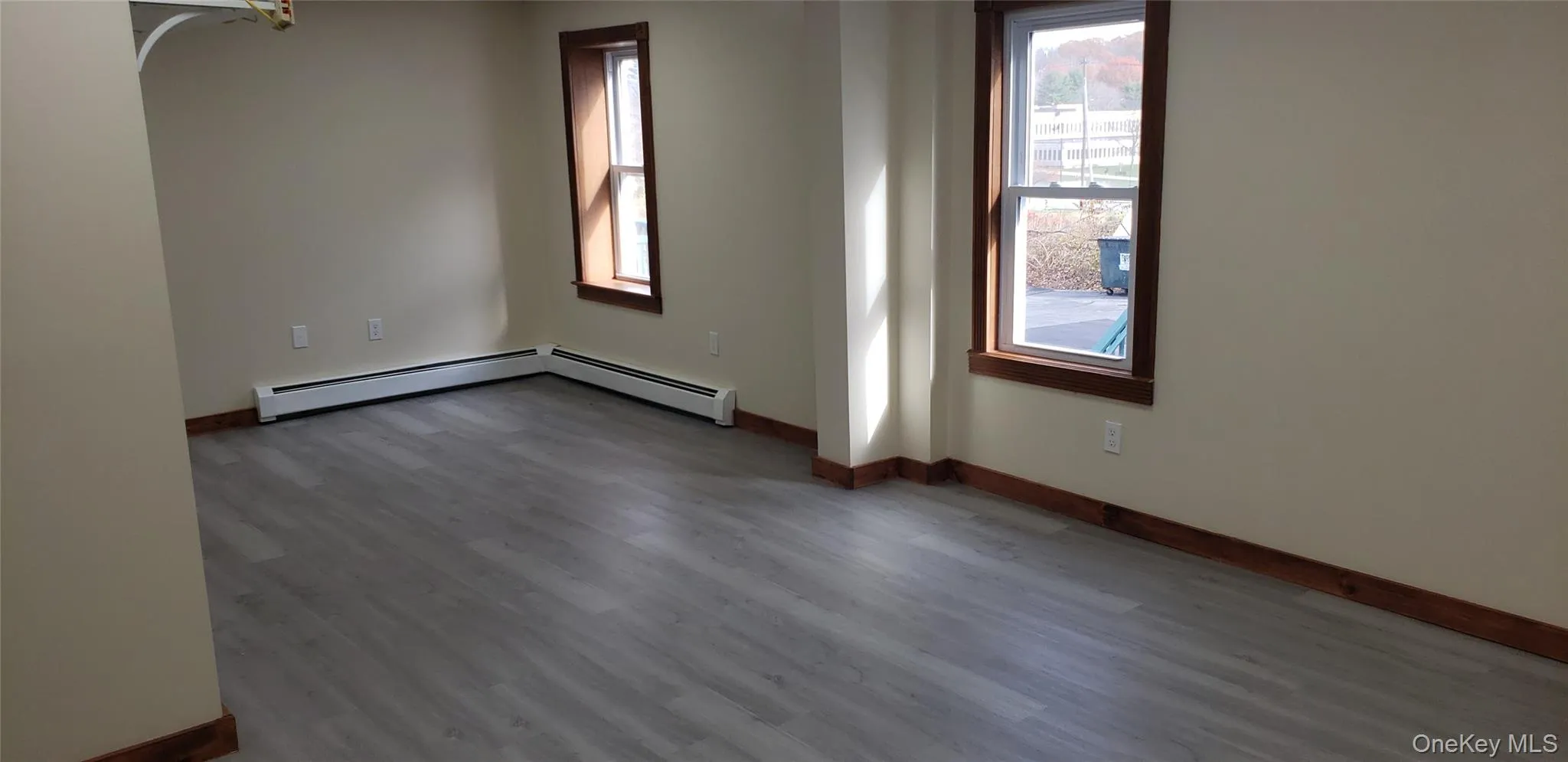 Spare room with wood finished floors and a baseboard heating unit Spare room with wood finished floors and a baseboard heating unit