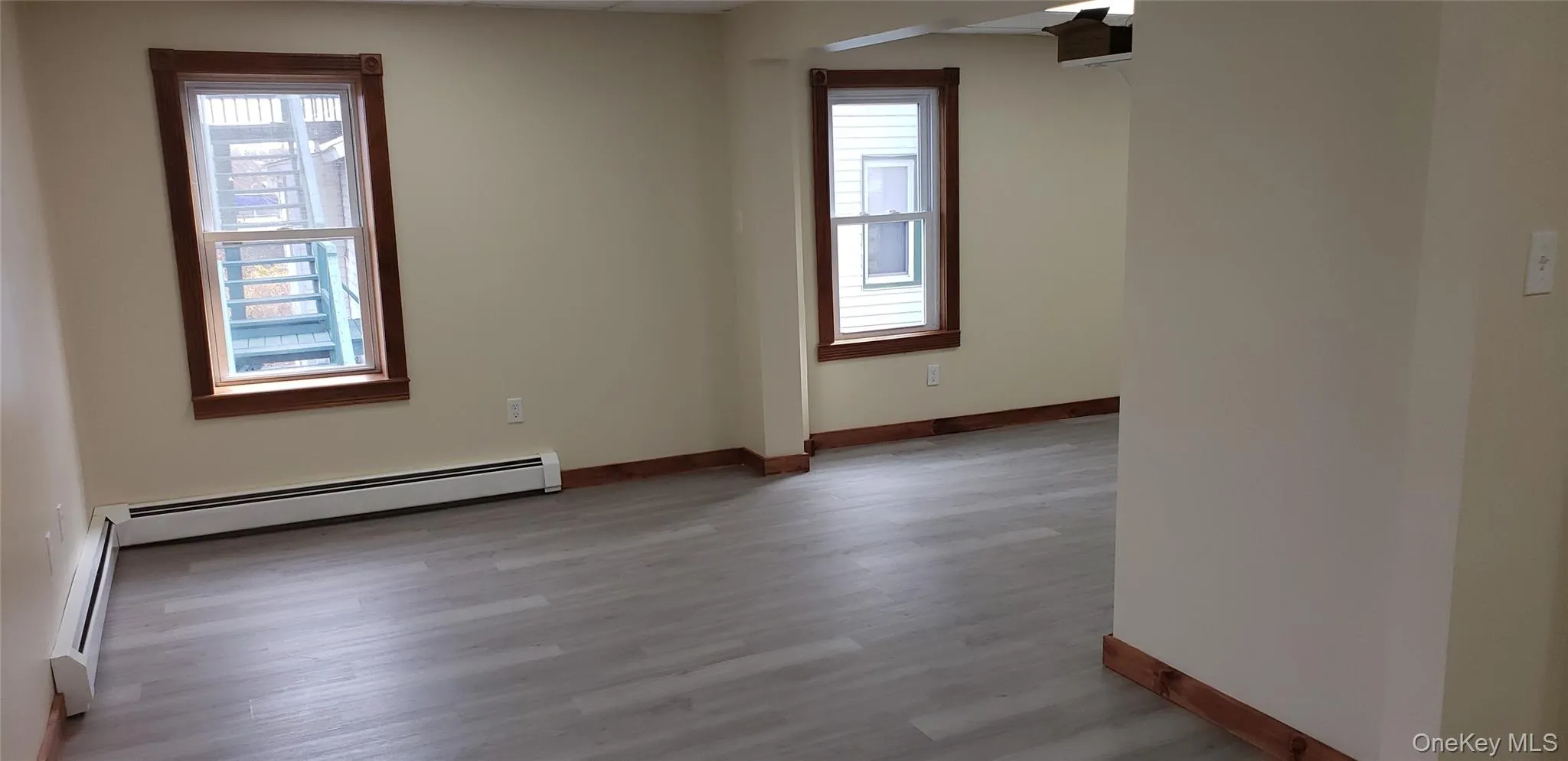 Unfurnished room with light wood-style floors and a baseboard heating unit Unfurnished room with light wood-style floors and a baseboard heating unit