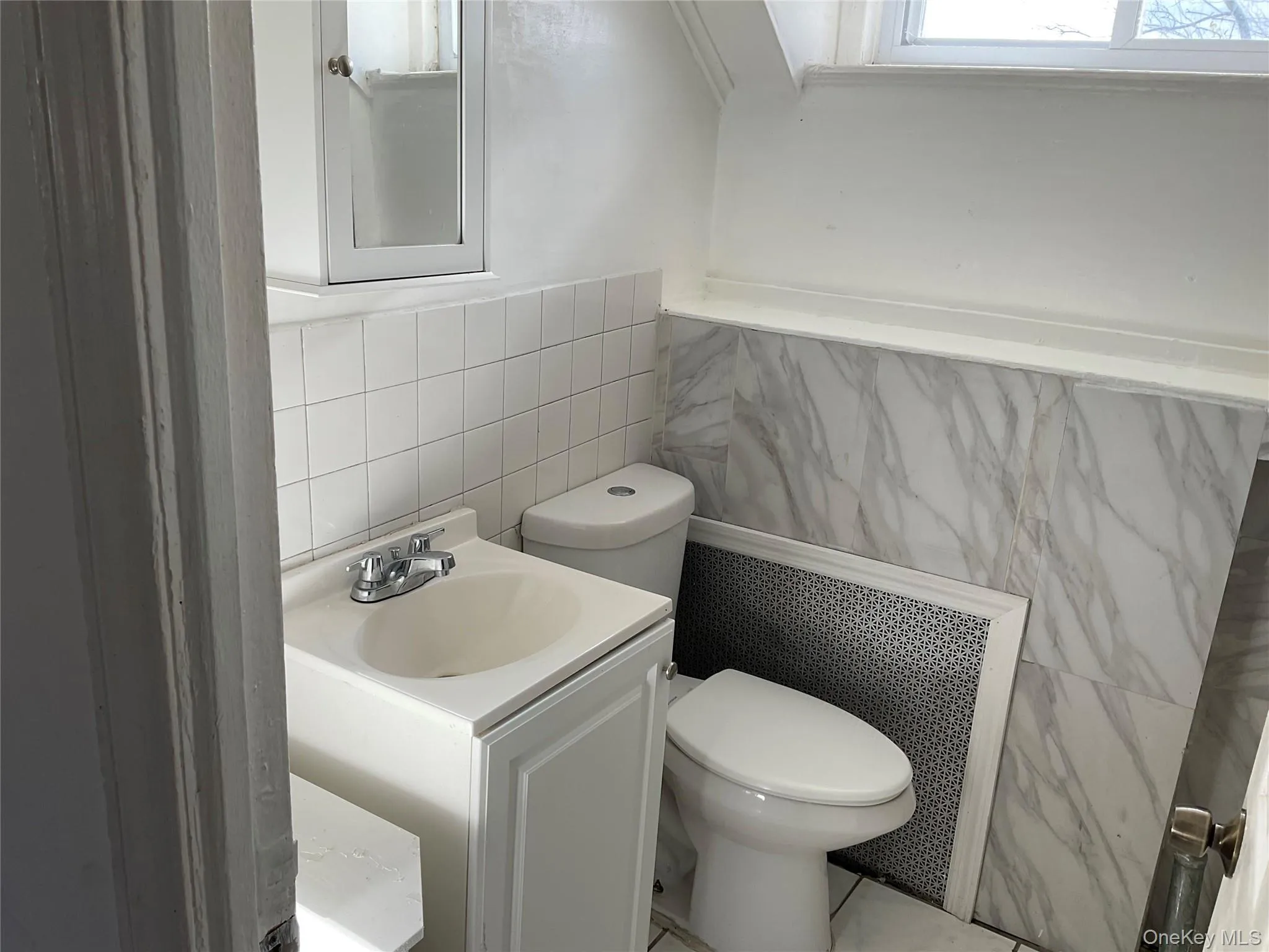Half bathroom with tile walls, vanity, and wainscoting Half bathroom with tile walls, vanity, and wainscoting