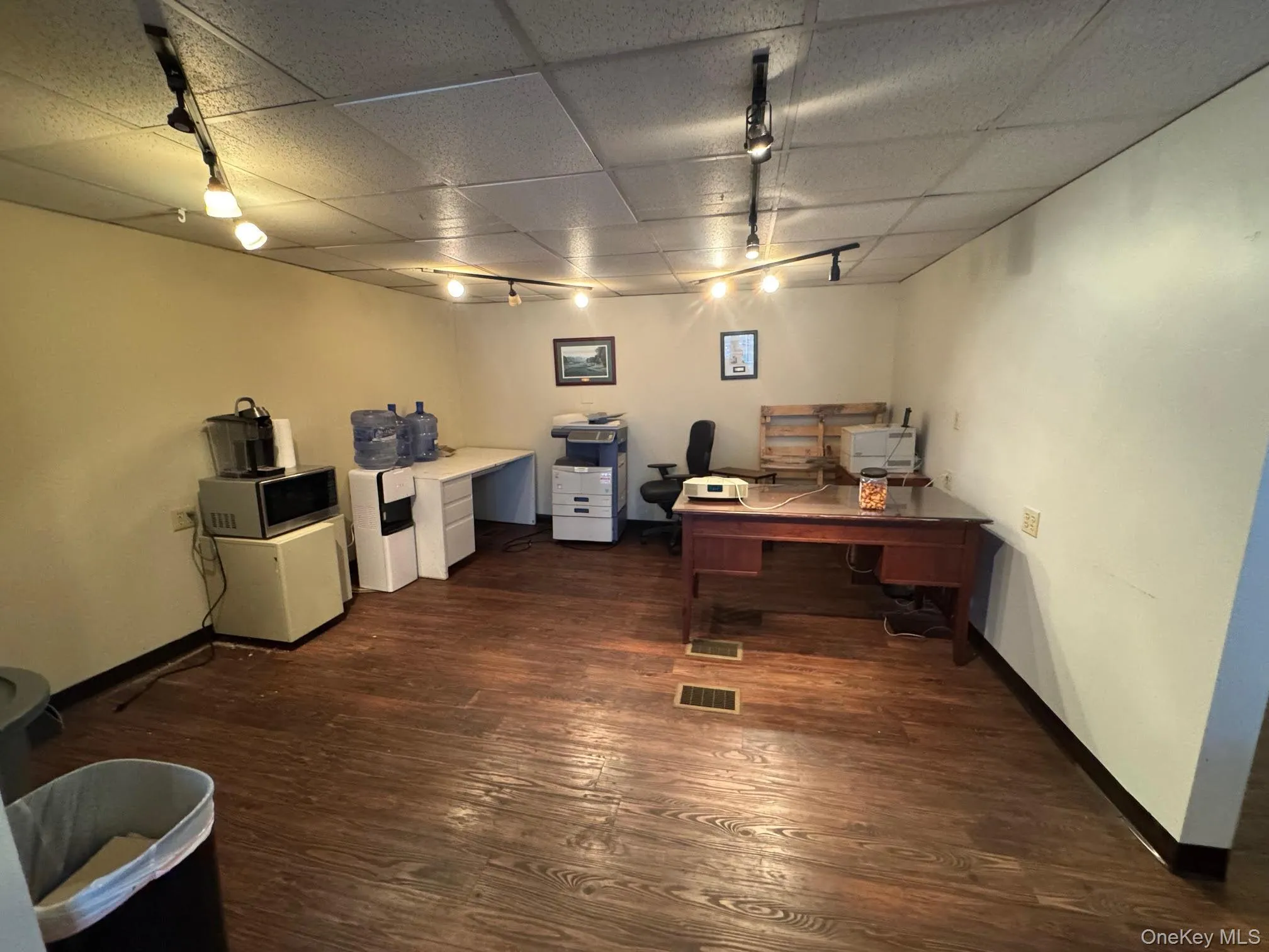 Office with track lighting, dark wood finished floors, and a drop ceiling Office with track lighting, dark wood finished floors, and a drop ceiling