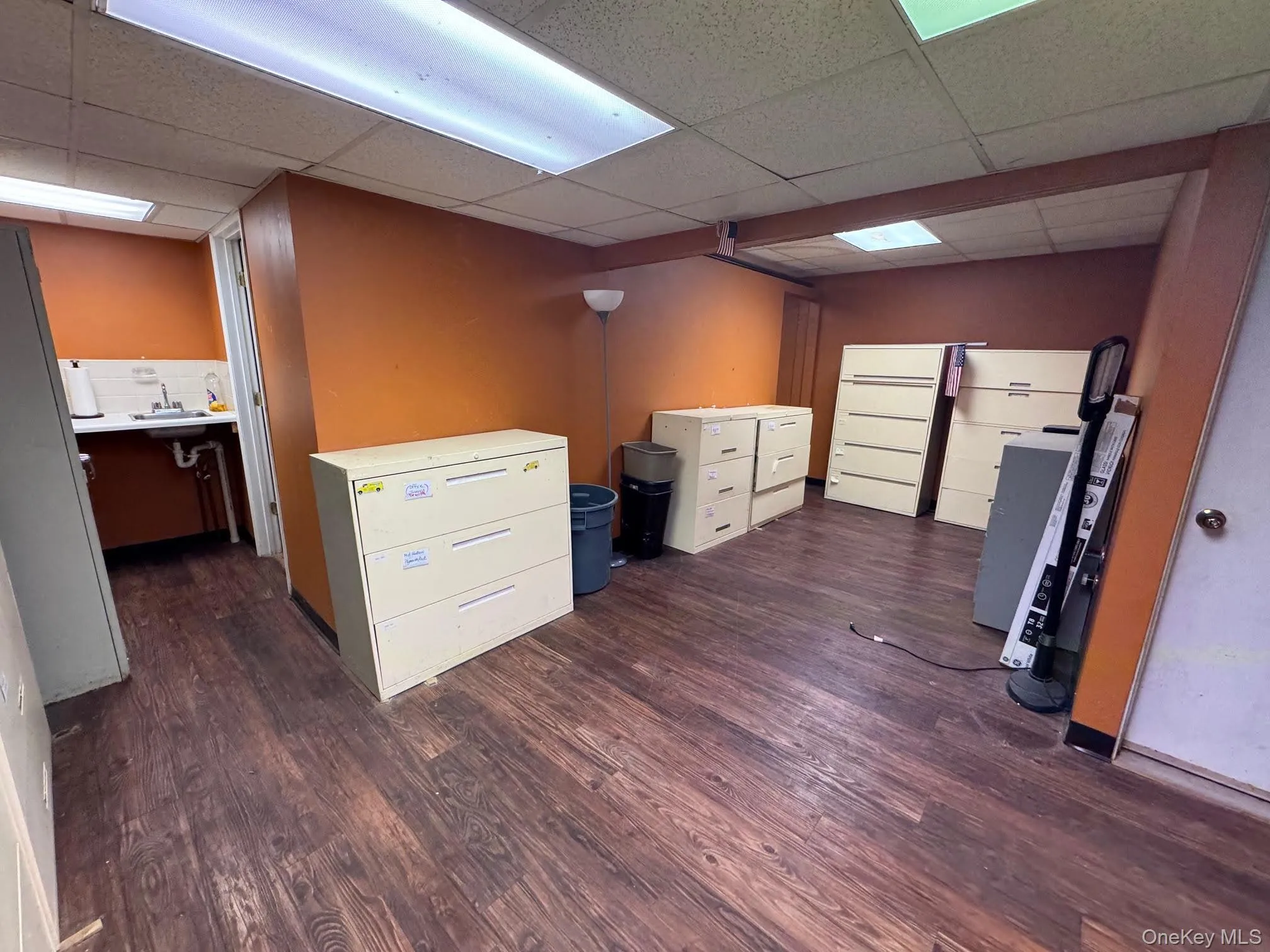 Unfurnished office featuring dark wood finished floors and a paneled ceiling Unfurnished office featuring dark wood finished floors and a paneled ceiling