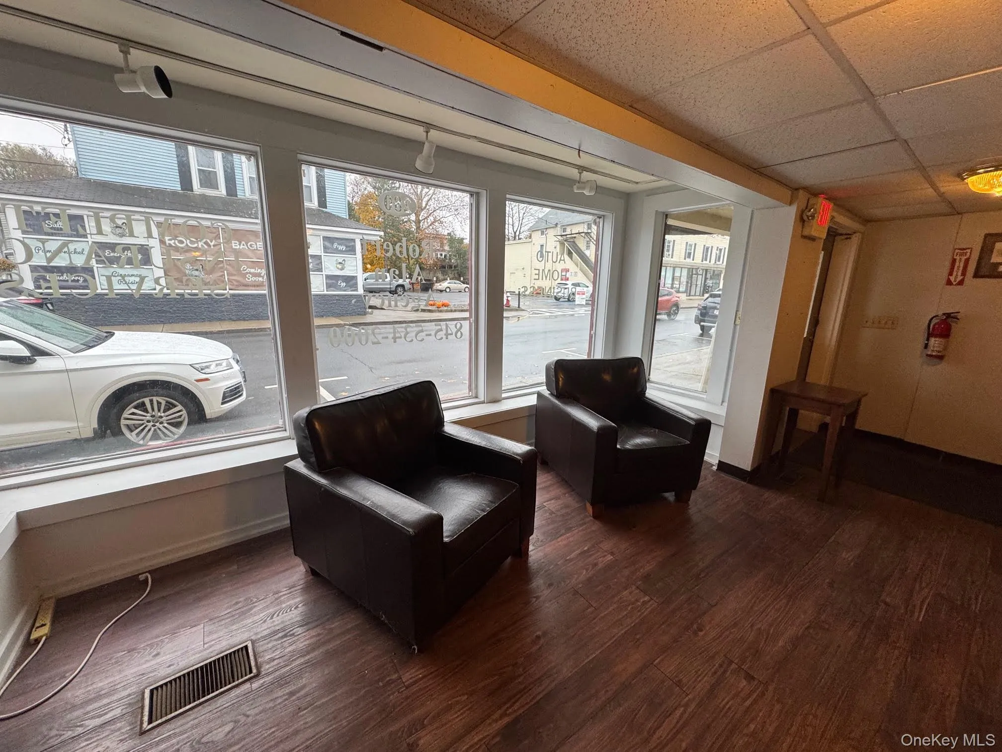 Living area featuring a drop ceiling and plenty of natural light Living area featuring a drop ceiling and plenty of natural light