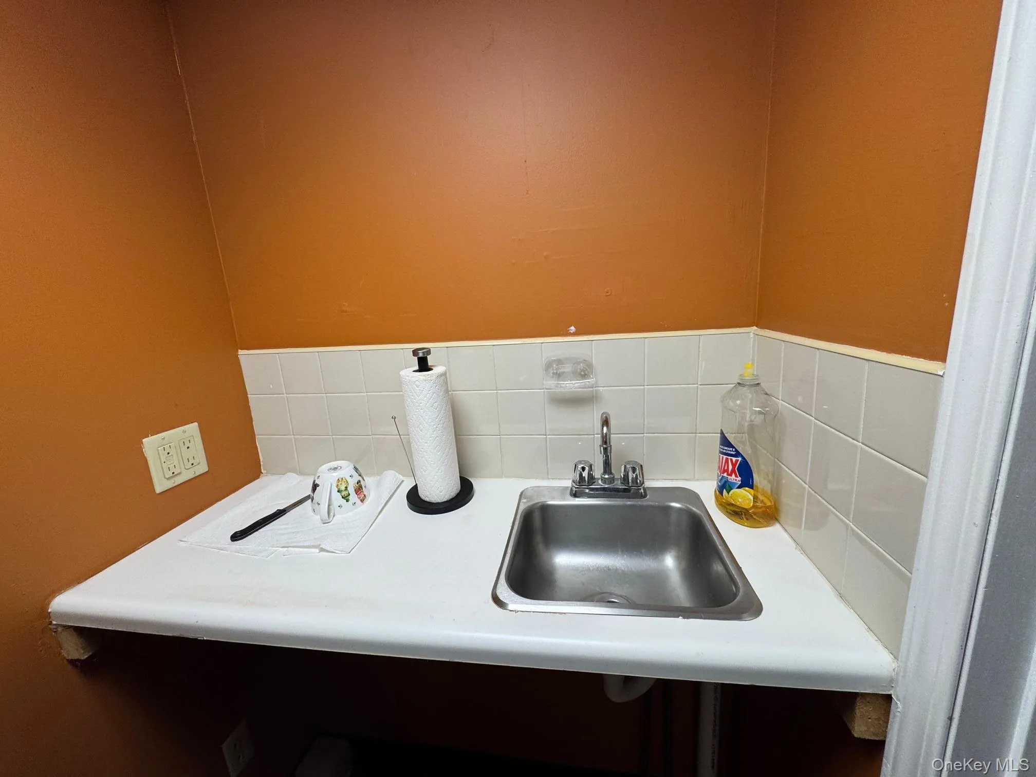 Bathroom featuring a sink and backsplash Bathroom featuring a sink and backsplash