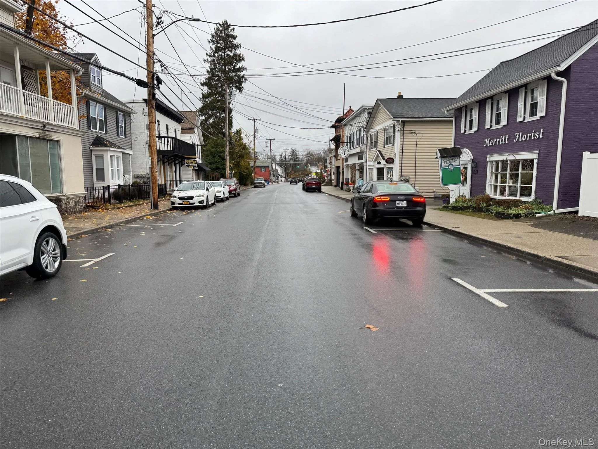 View of asphalt street with curbs, sidewalks, a residential view, and street lighting View of asphalt street with curbs, sidewalks, a residential view, and street lighting