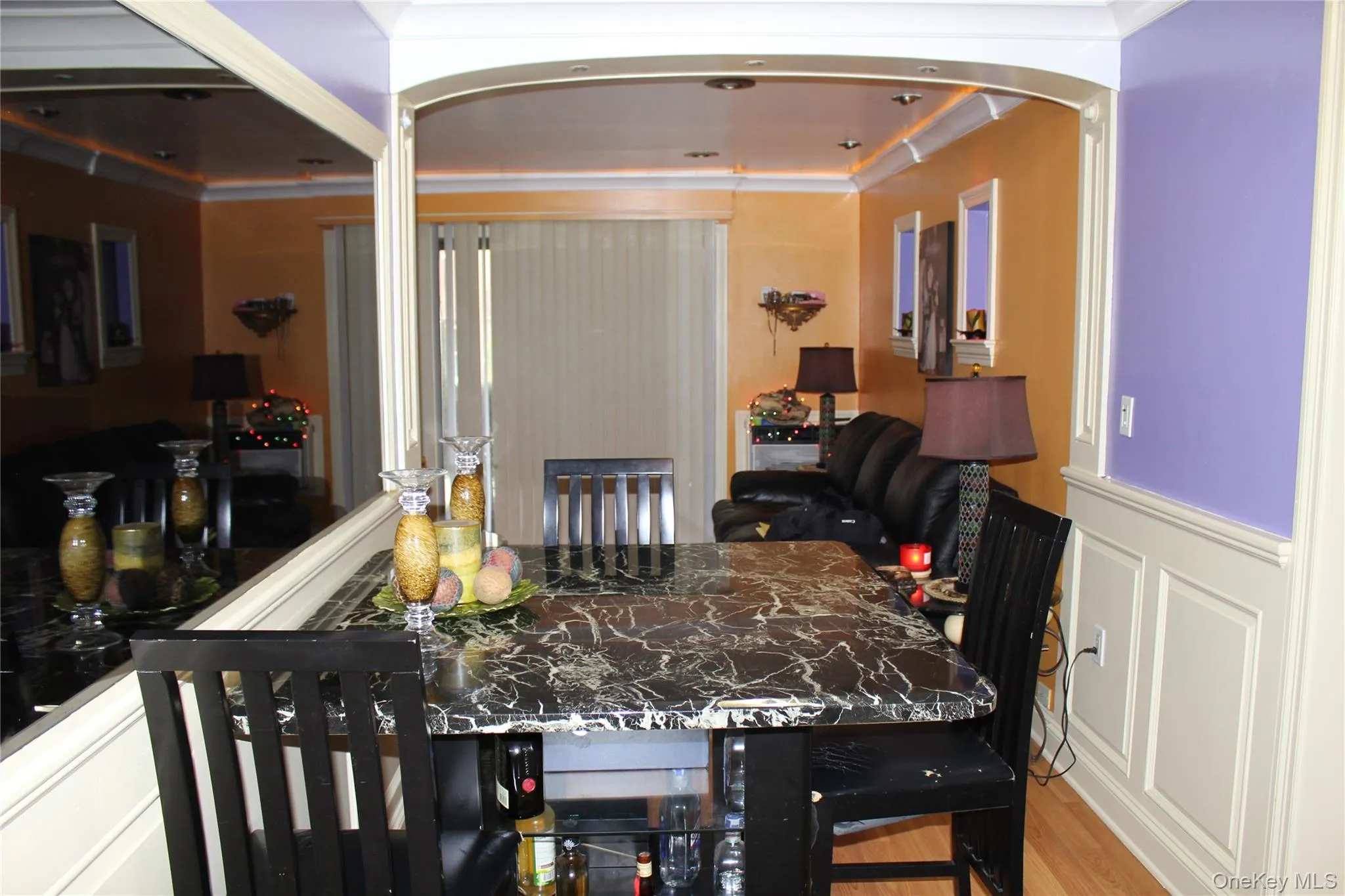 Dining area with wood finished floors, a wainscoted wall, and a decorative wall Dining area with wood finished floors, a wainscoted wall, and a decorative wall