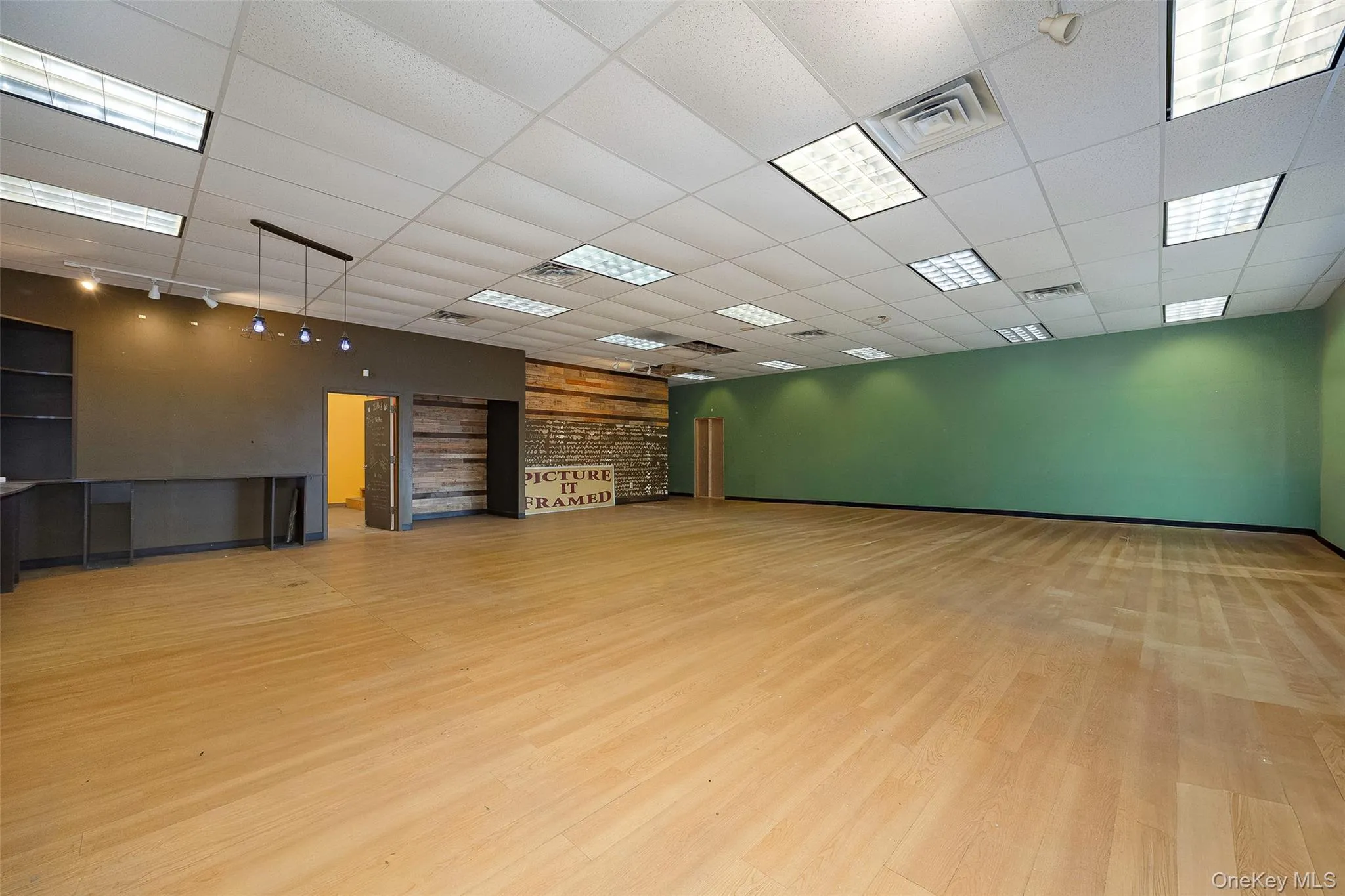 Empty room featuring light wood finished floors and a paneled ceiling Empty room featuring light wood finished floors and a paneled ceiling