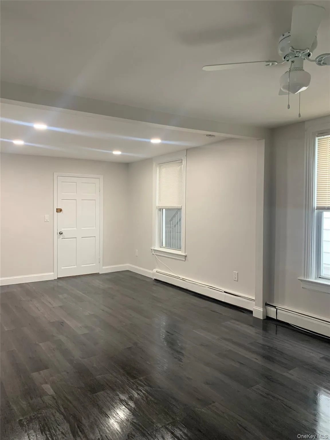 Spare room with dark wood-style flooring, ceiling fan, a baseboard radiator, and recessed lighting Spare room with dark wood-style flooring, ceiling fan, a baseboard radiator, and recessed lighting