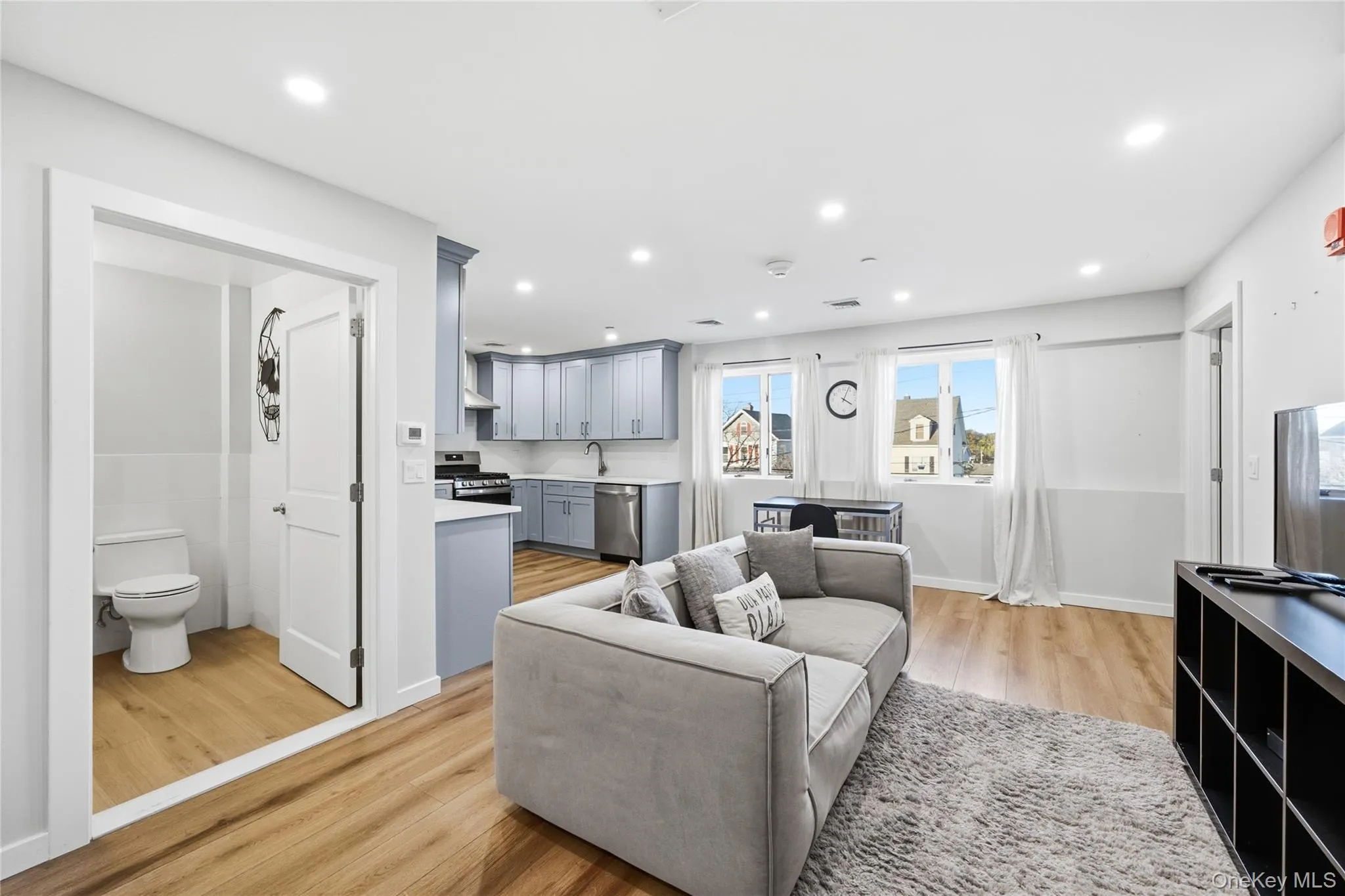 Living room with light wood finished floors and recessed lighting Living room with light wood finished floors and recessed lighting